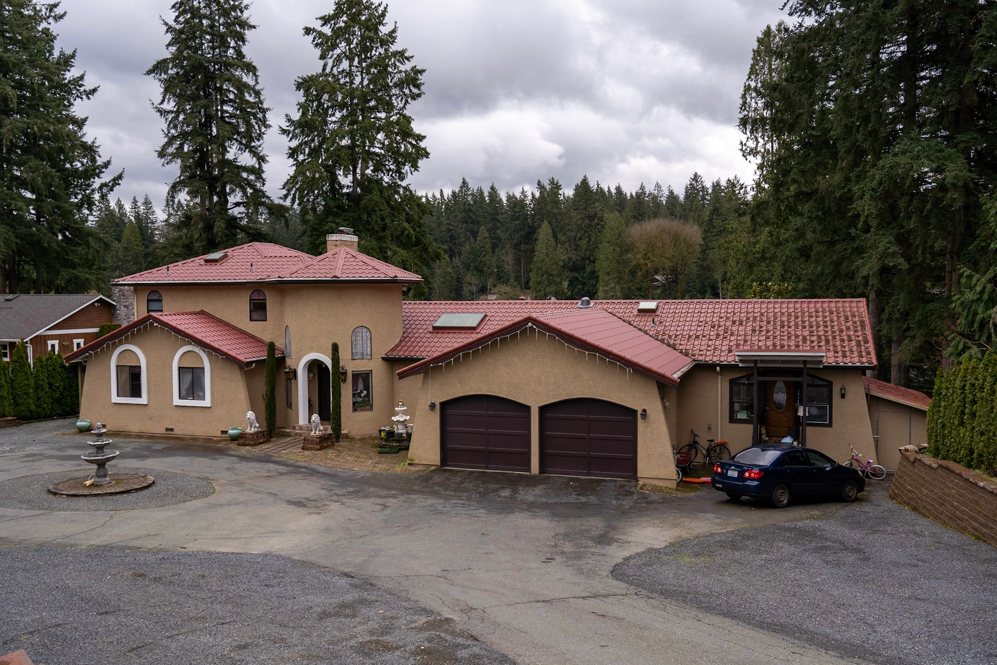 Tile Red Interlock Tile aluminum roof on a tan home with a red tile roof in a forest, Woodinville, Washington