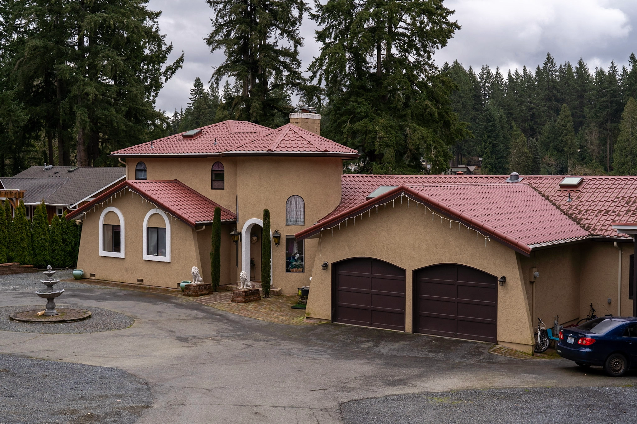 Tile Red Interlock Tile aluminum roof on a tan single-family home with a tile red metal roof in, Woodinville, Washington