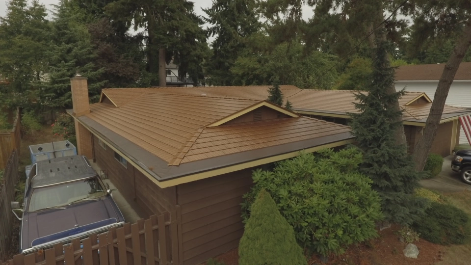 Aged Copper Interlock Cedar Shingle aluminum roof on a brown one-storey ranch home with a metal roof in a, Bellevue, Washington