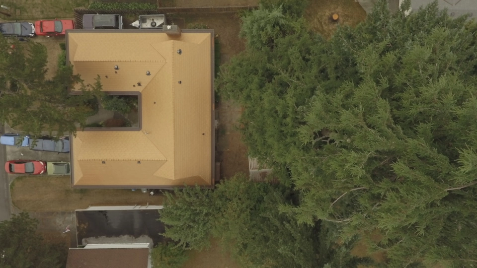 Aged Copper Interlock Cedar Shingle aluminum roof on a brown ranch-style home with a metal roof in a suburban, Bellevue, Washington