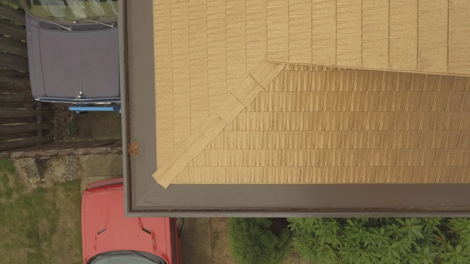 Aged Copper Interlock Cedar Shingle aluminum roof on a red house with a metal roof in a residential area, Bellevue, Washington