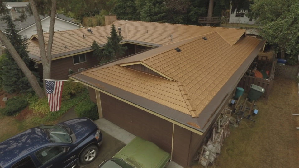 Aged Copper Interlock Cedar Shingle aluminum roof on a brown one-storey home with a hip roof in a suburban area, Bellevue, Washington