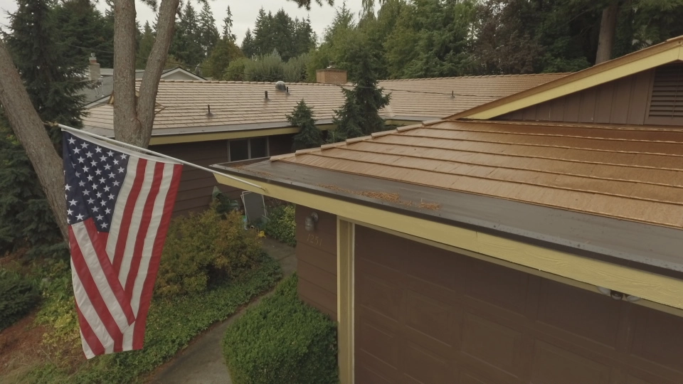 Aged Copper Interlock Cedar Shingle aluminum roof on a brown single-storey home with an overhanging eave among, Bellevue, Washington
