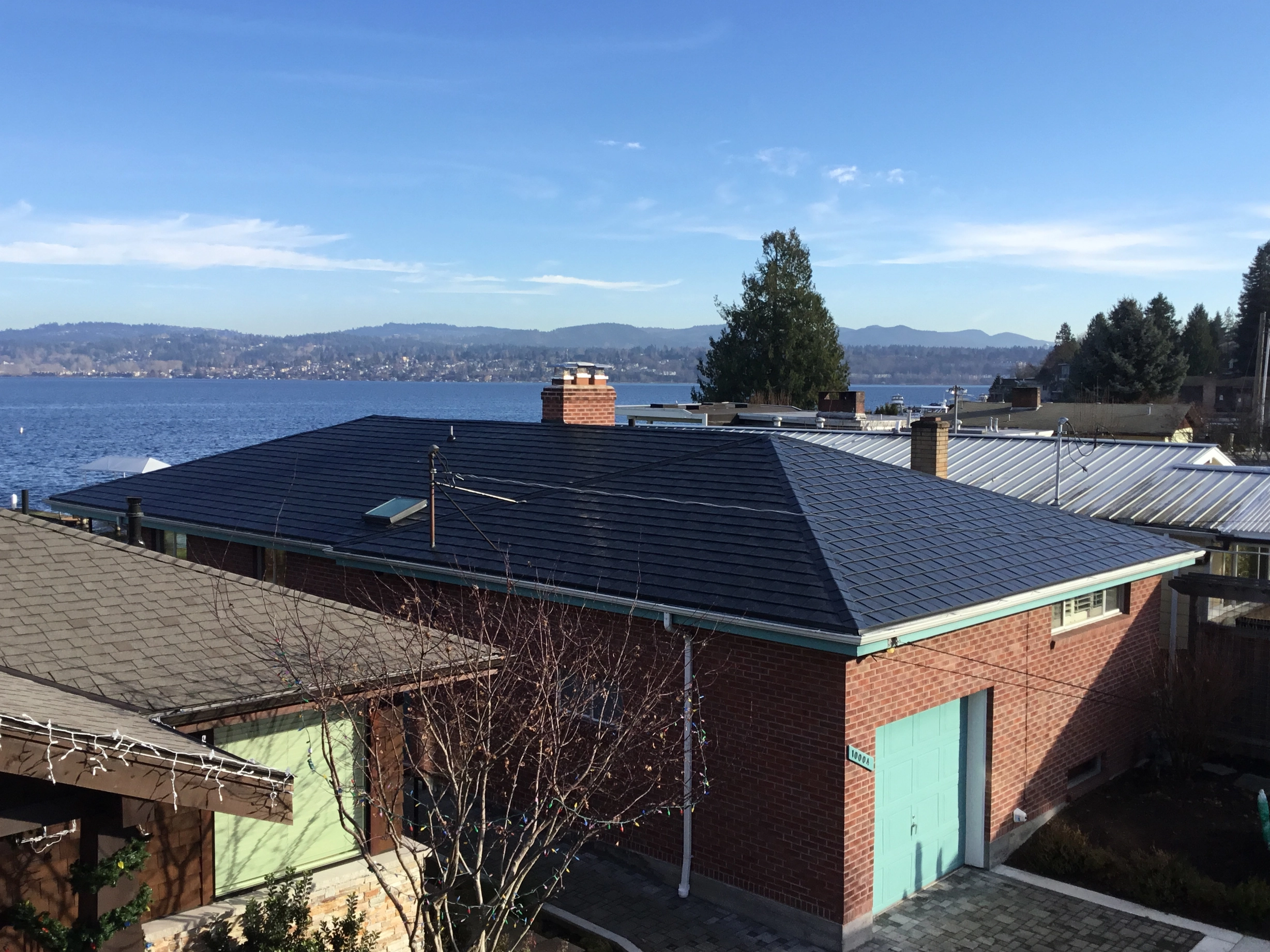 Black Interlock Slate aluminum roof on a brick house with a metal roof overlooking the ocean, Seattle, Washington