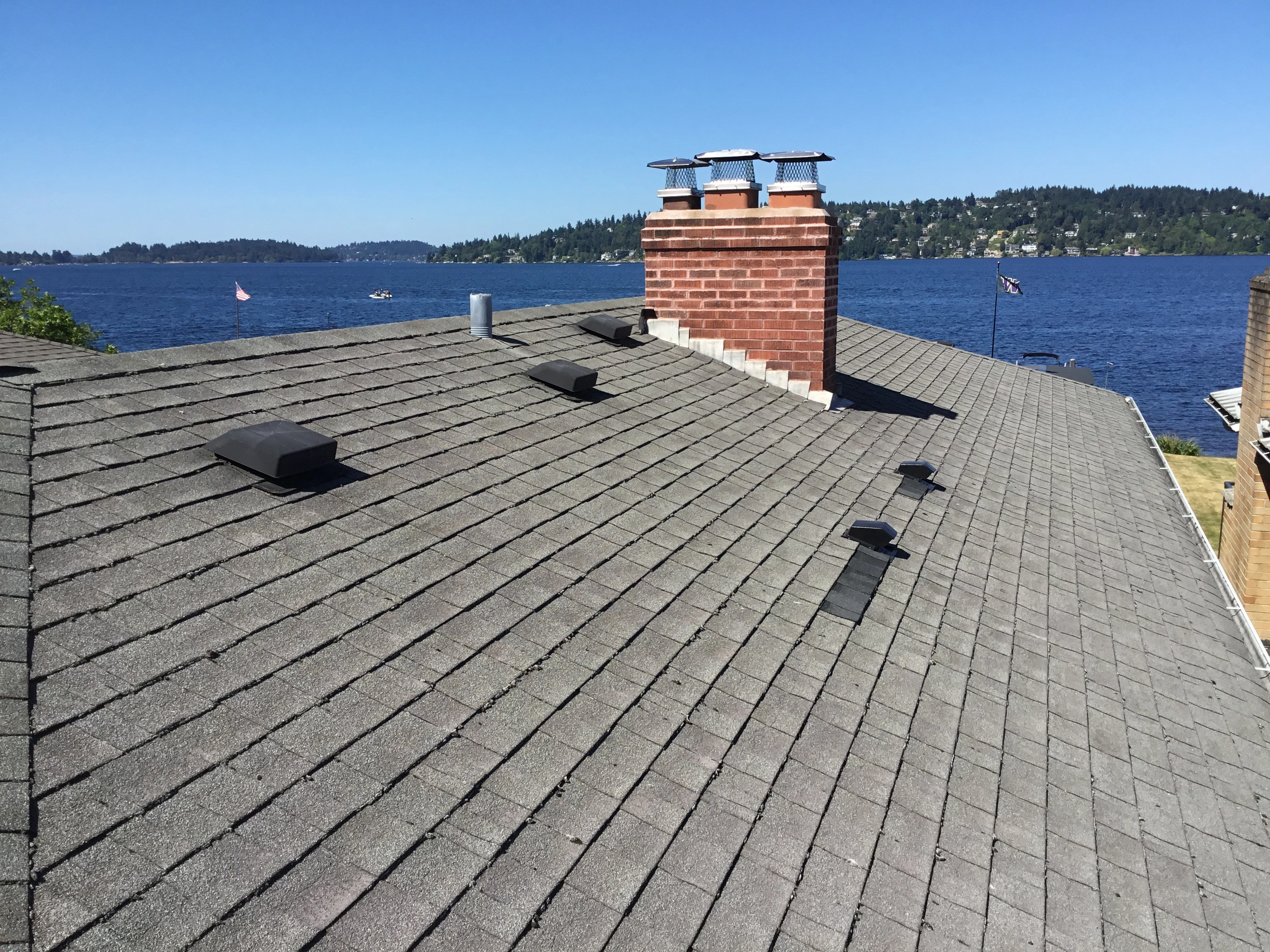 Before: a worn out asphalt shingle roof on the home, Seattle, Washington, ahead of a Black Interlock Slate aluminum roof