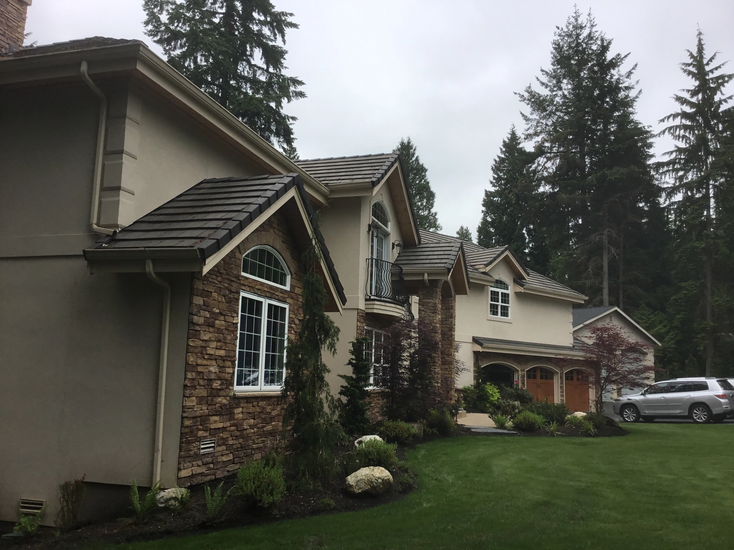 Before: a worn out concrete tile roof on the home, Bothell, Washington, ahead of a Black Interlock Slate aluminum roof