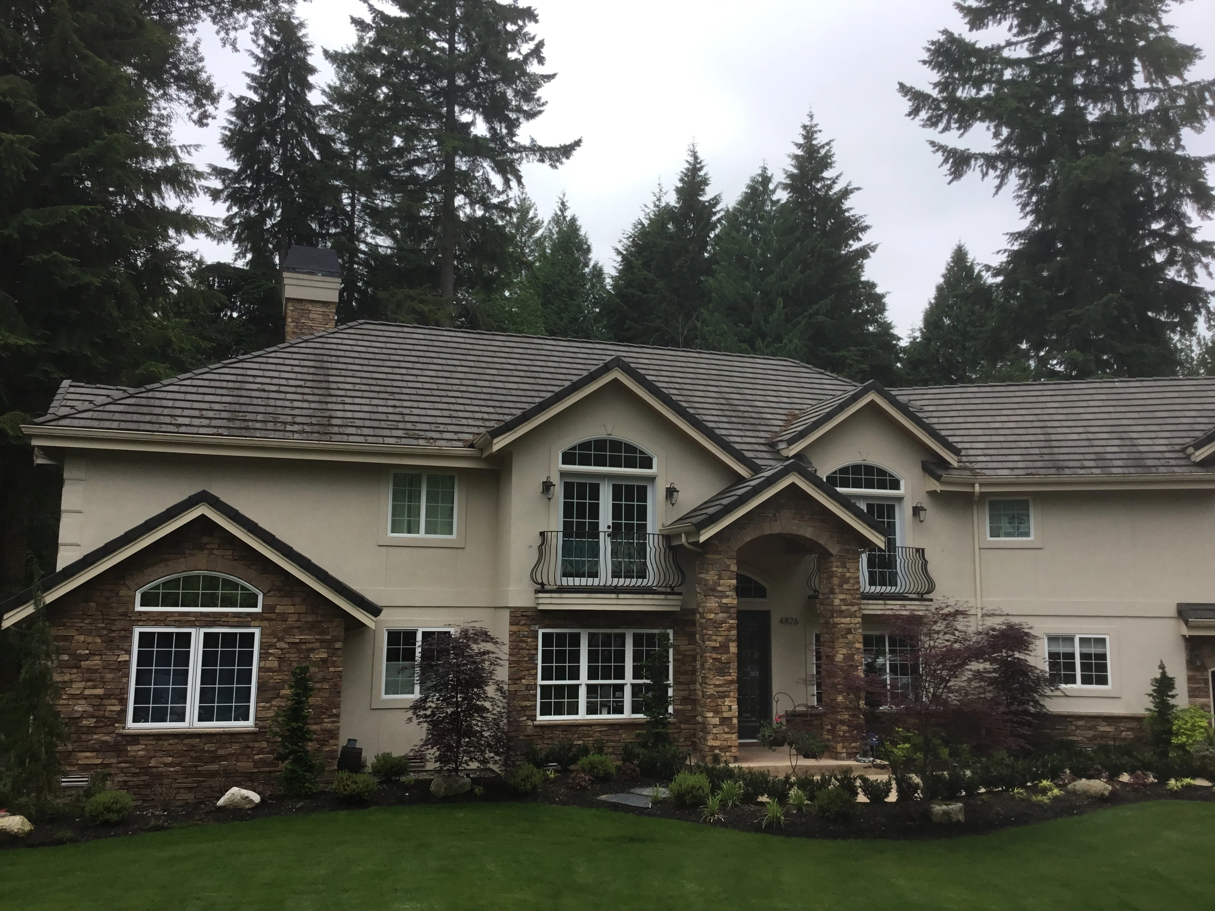 Before: a worn out concrete tile roof on the home, Bothell, Washington, ahead of a Black Interlock Slate aluminum roof