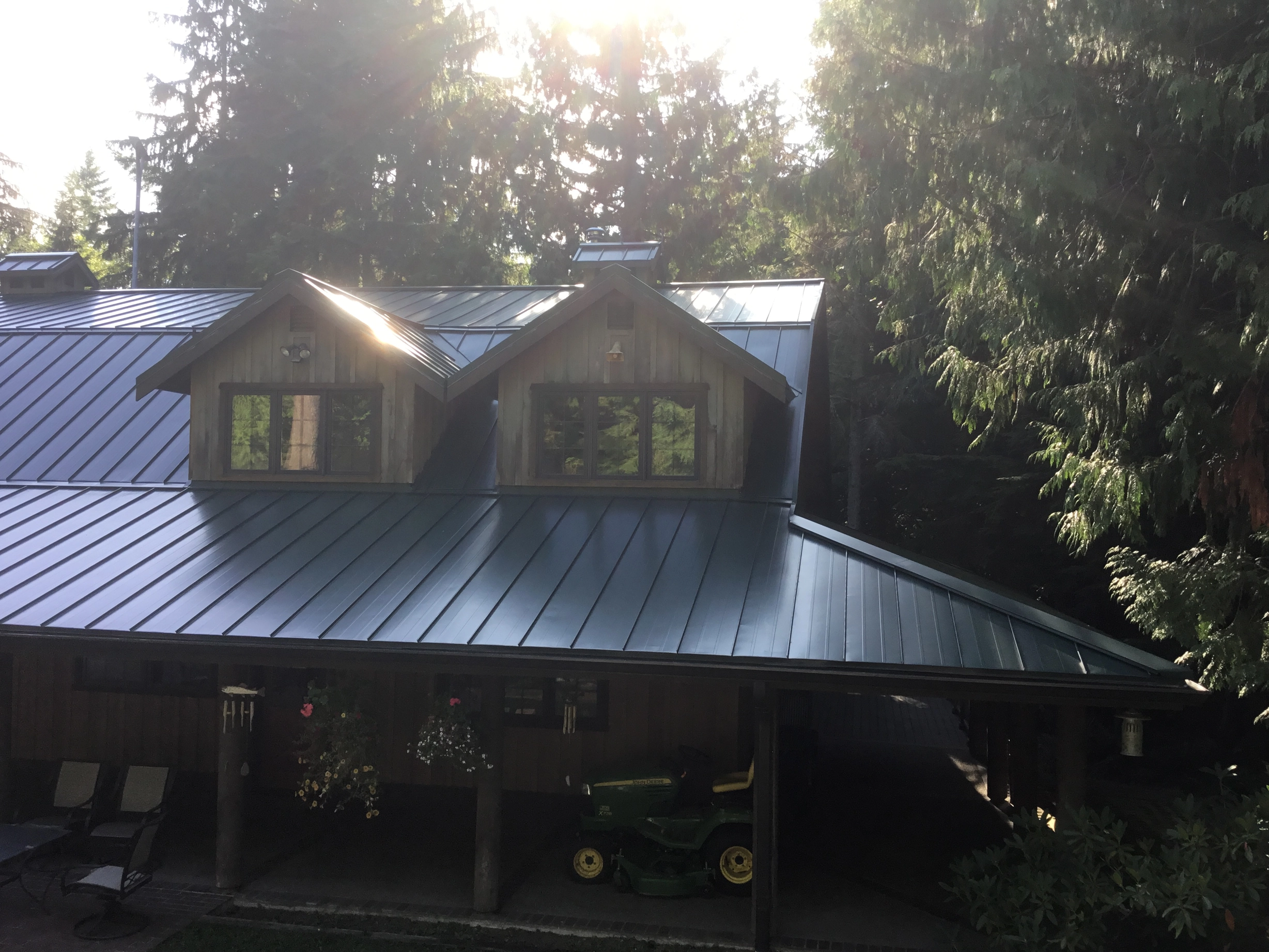 Hunter Green Interlock Standing Seam aluminum roof on a single-storey house with a green metal roof in a forest, Preston, Washington