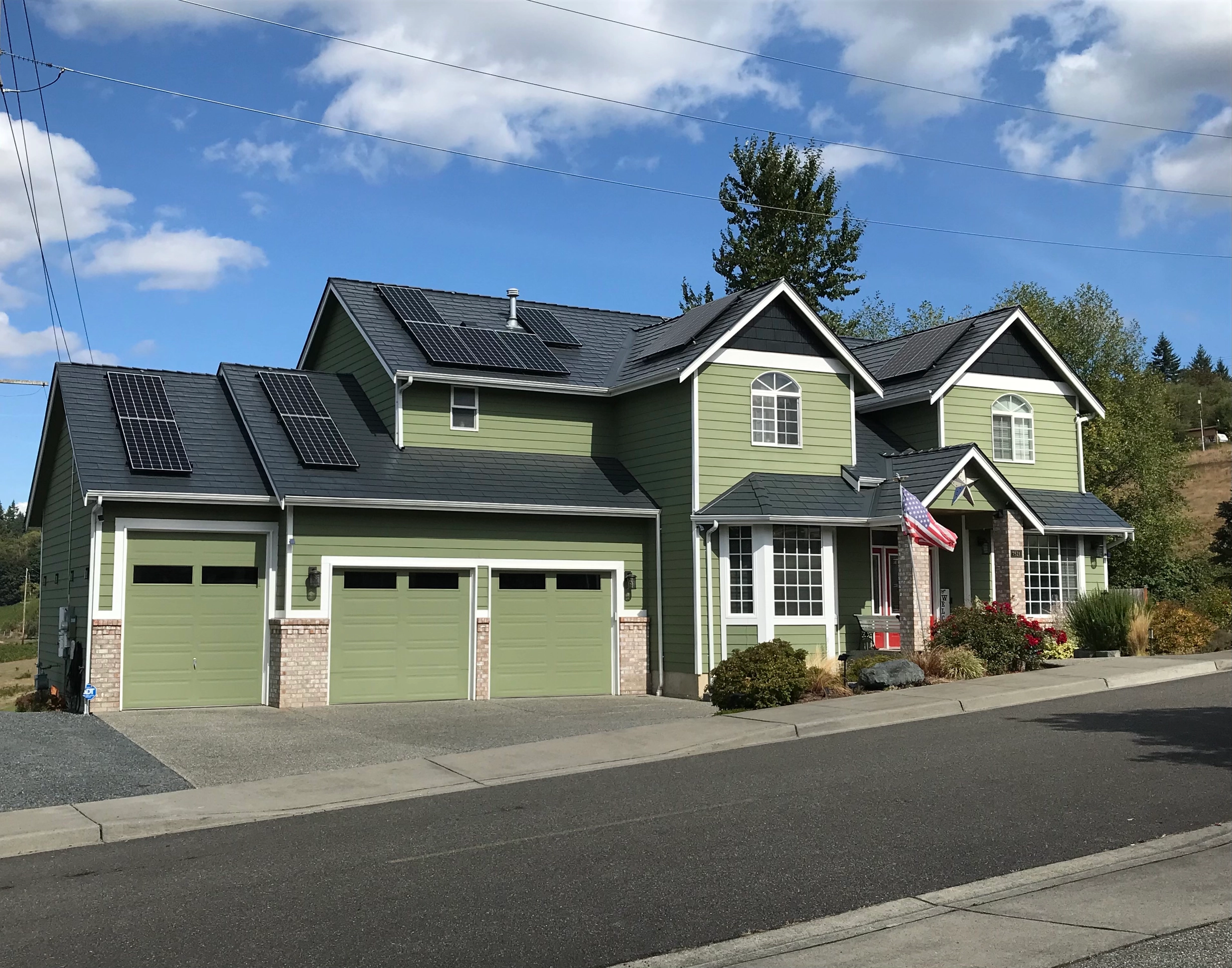 Deep Charcoal Interlock Slate aluminum roof on a two-storey modern home with a green exterior in a, Marysville, Washington
