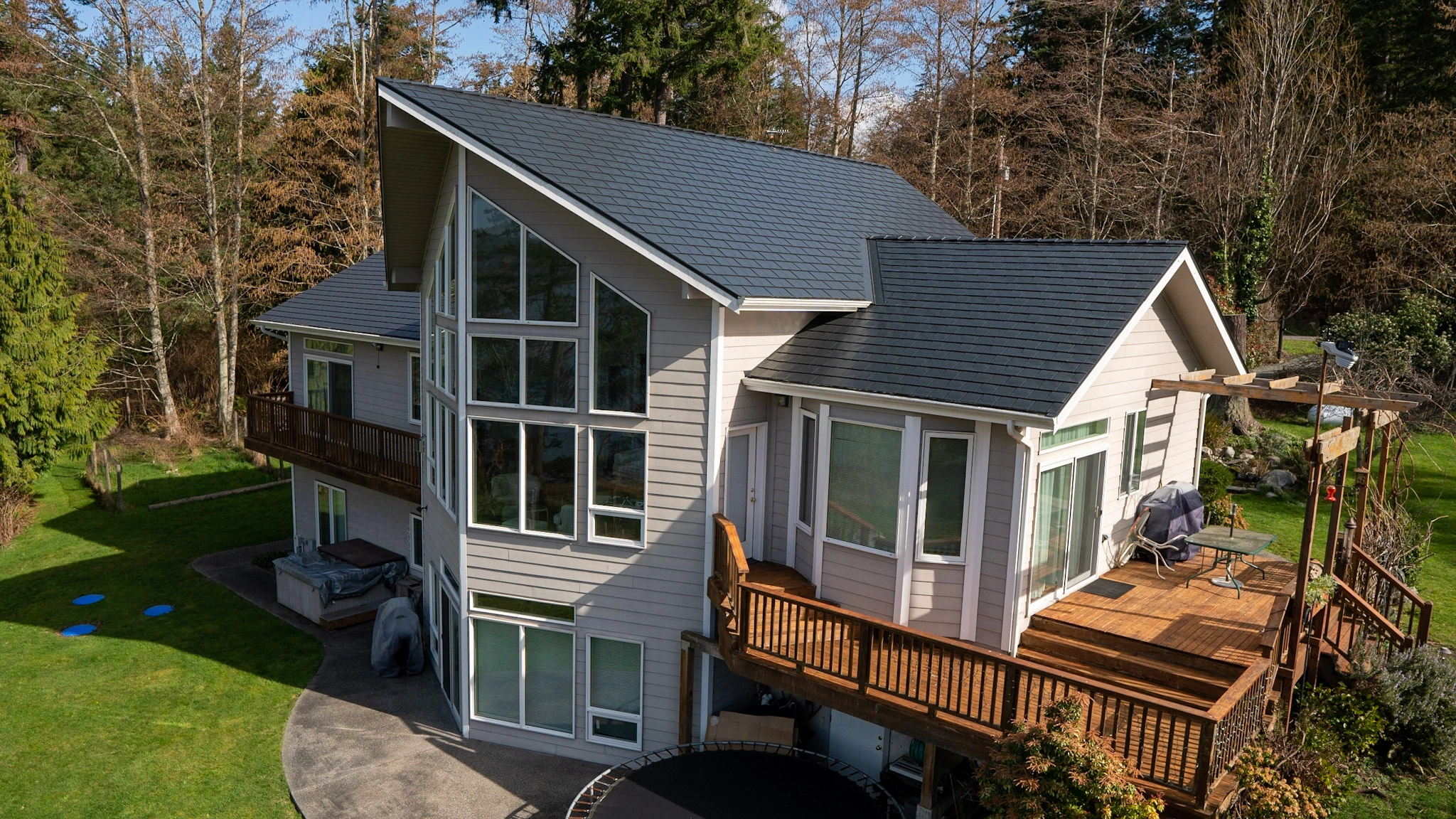 Black Interlock Slate aluminum roof on a white house with a metal roof in a forested area, Langley, Washington