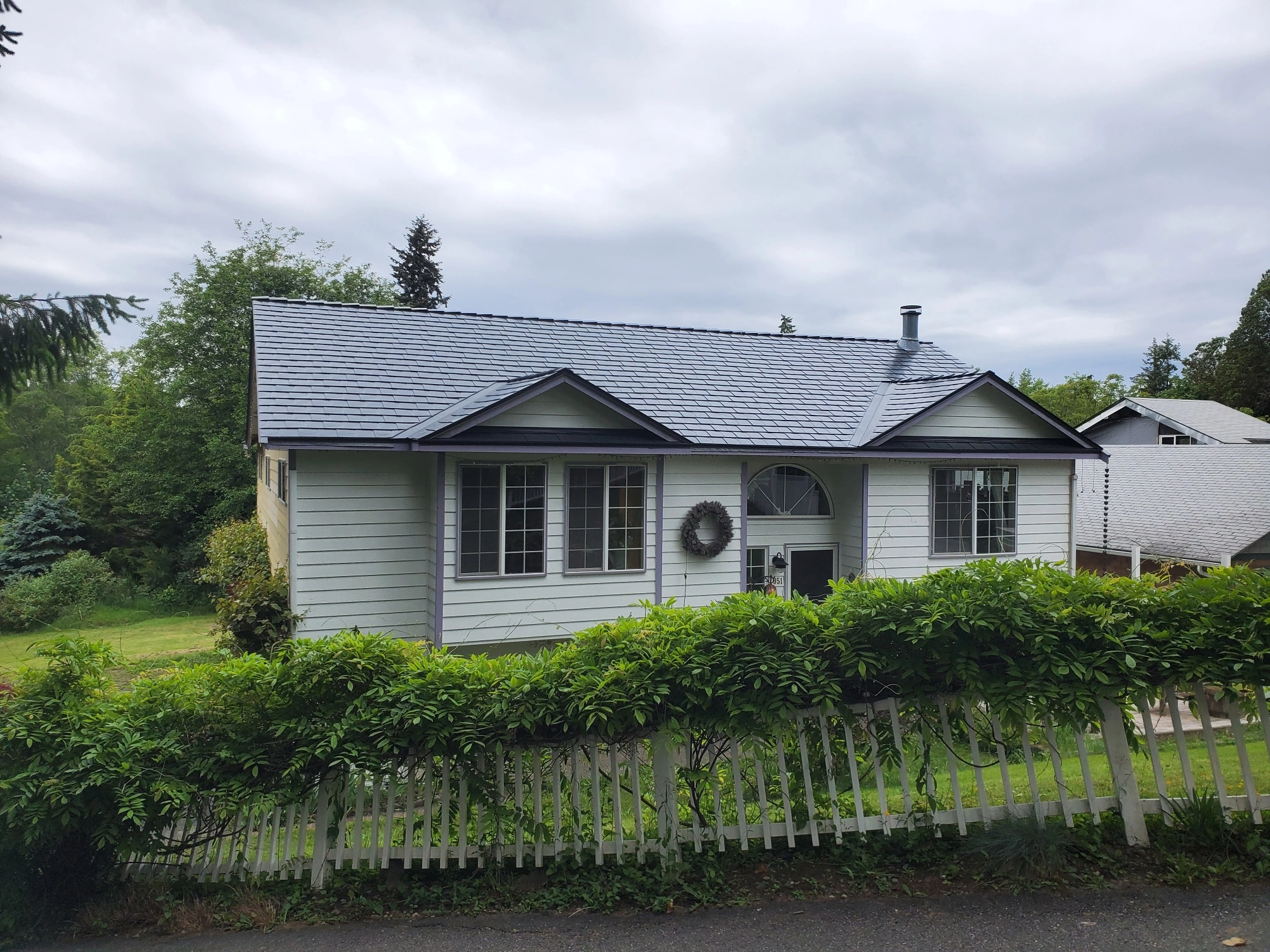 Black Interlock Slate aluminum roof on a white home with a metal roof in a rural setting, Bremerton, Washington