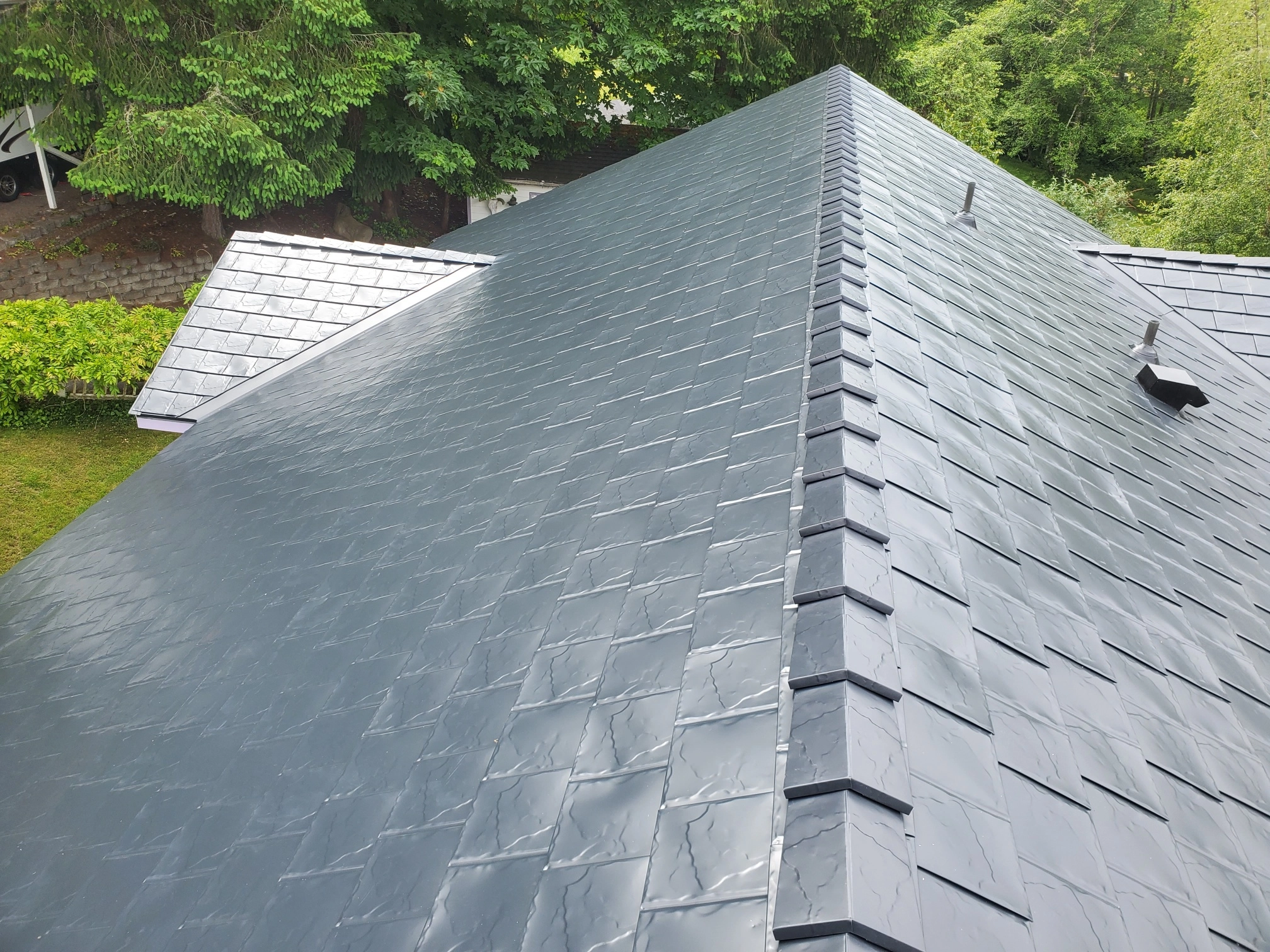 Black Interlock Slate aluminum roof on a black home with a metal roof in a forested rural area, Bremerton, Washington