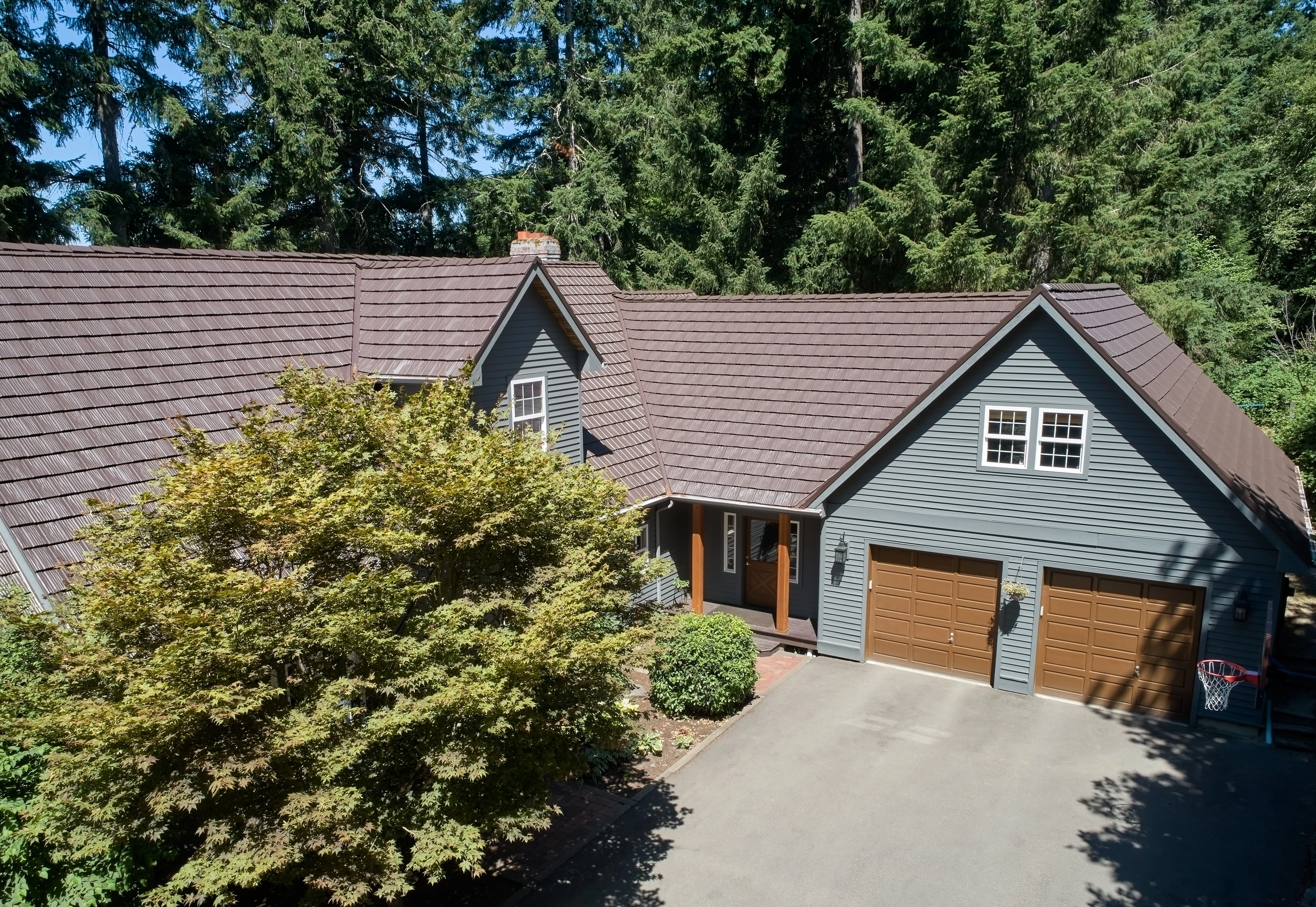 Colonial Brown Interlock Shake aluminum roof on a colonial style home with a brown metal roof in a forested, Gig Harbor, Washington
