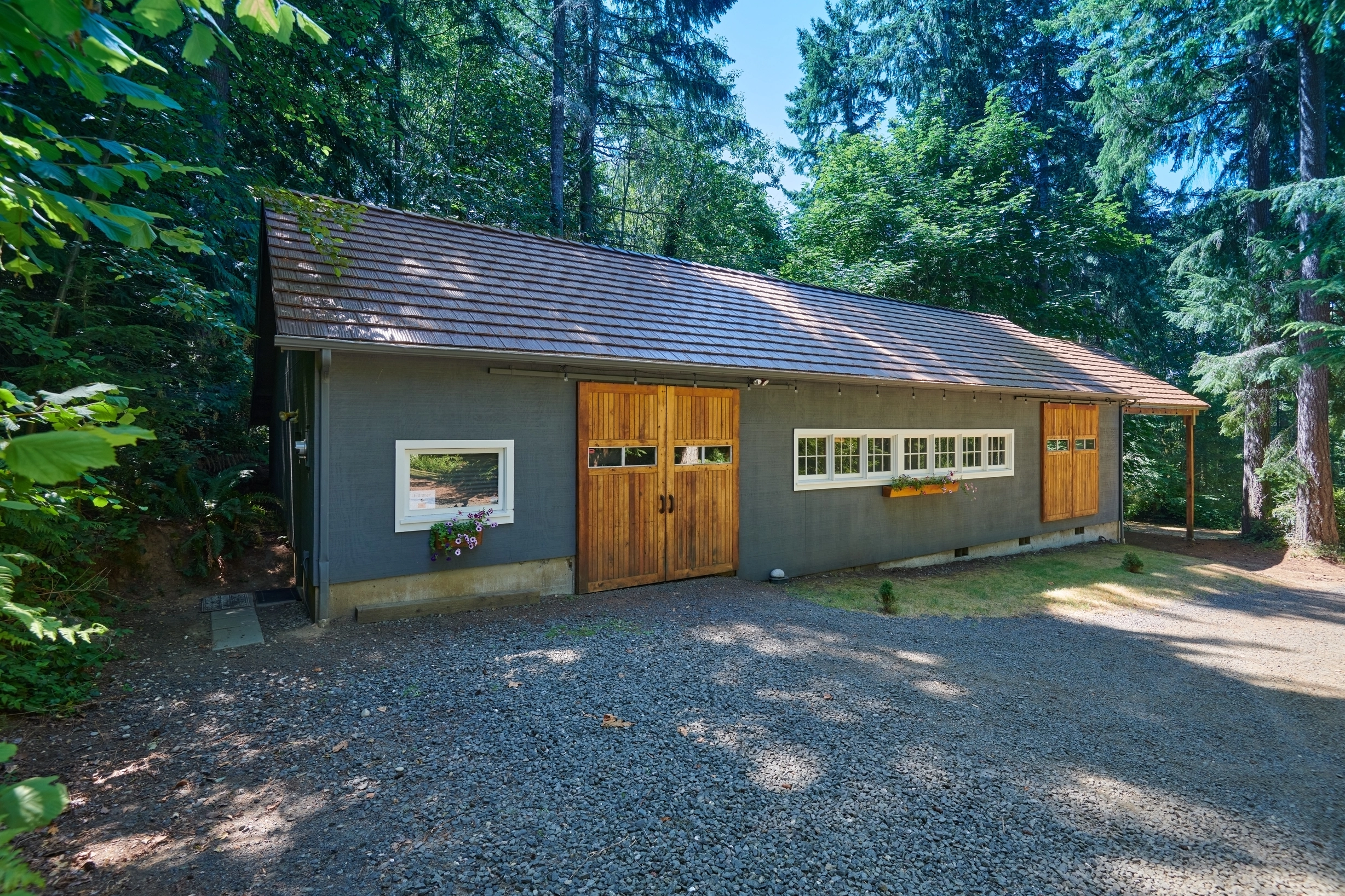 Colonial Brown Interlock Shake aluminum roof on a Colonial brown metal roof on a gray house in a forested, Gig Harbor, Washington