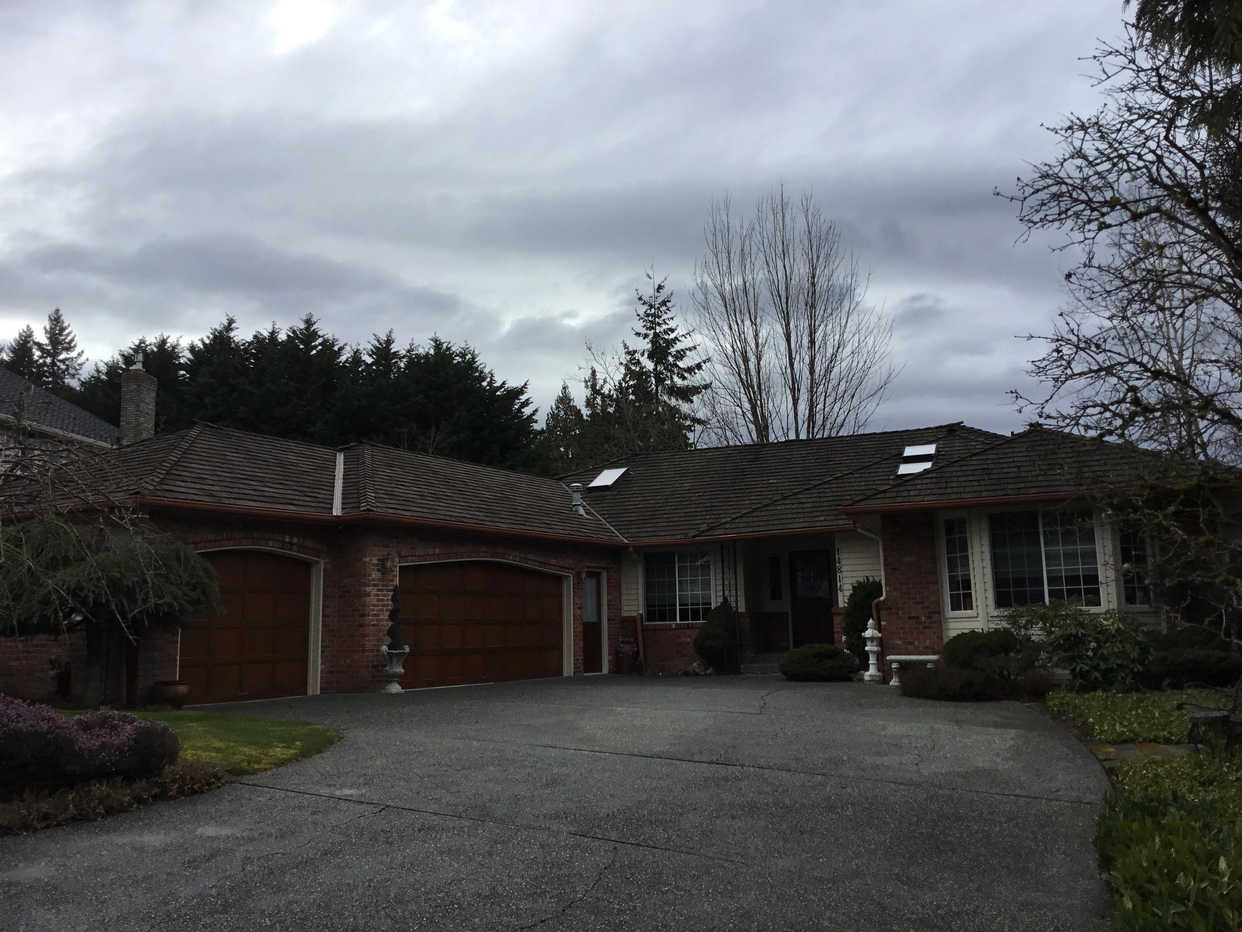 Before: a worn out wood shake roof on the home, Mill Creek, Washington, ahead of a Tudor Brown Interlock Cedar Shingle aluminum roof