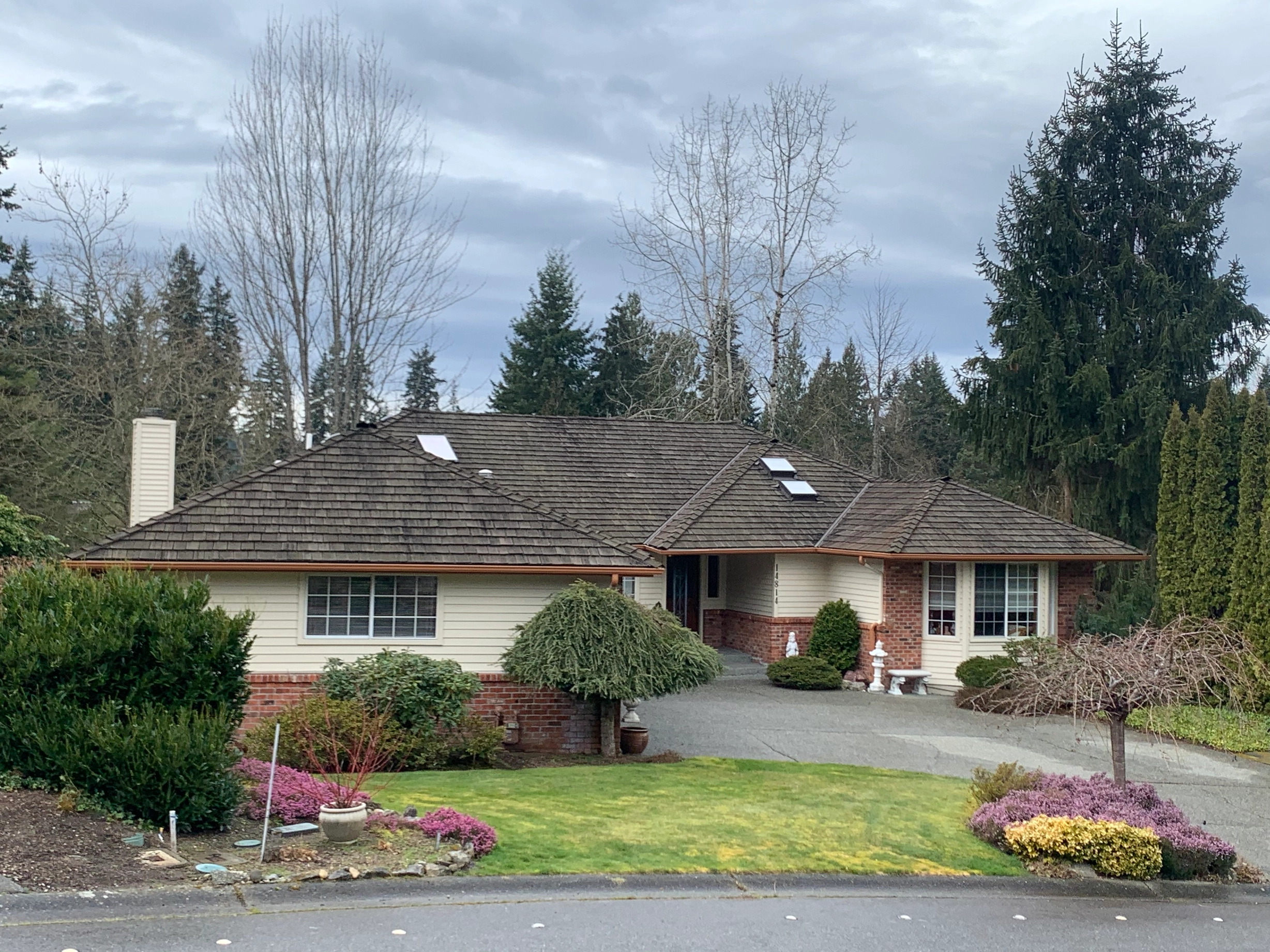 Before: a worn out wood shake roof on the home, Mill Creek, Washington, ahead of a Tudor Brown Interlock Cedar Shingle aluminum roof
