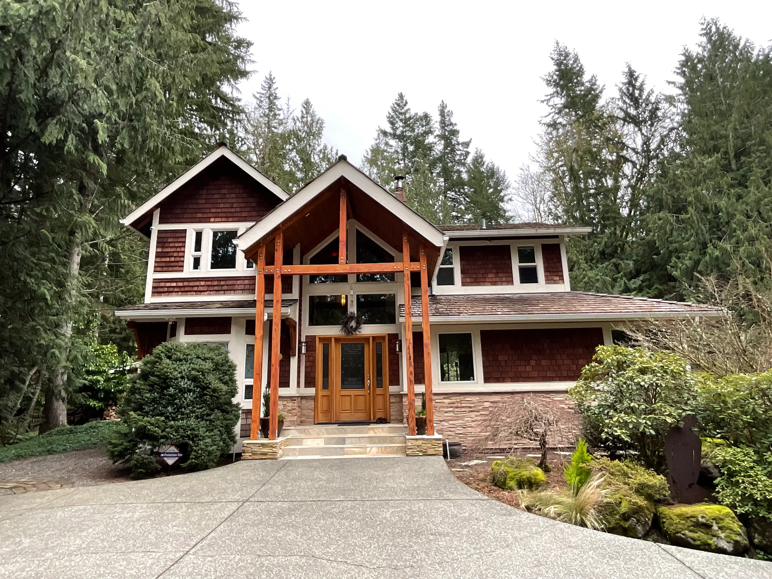 Before: a curling wood shake roof on the home, Fall City, Washington, ahead of a Hunter Green Interlock Standing Seam aluminum roof