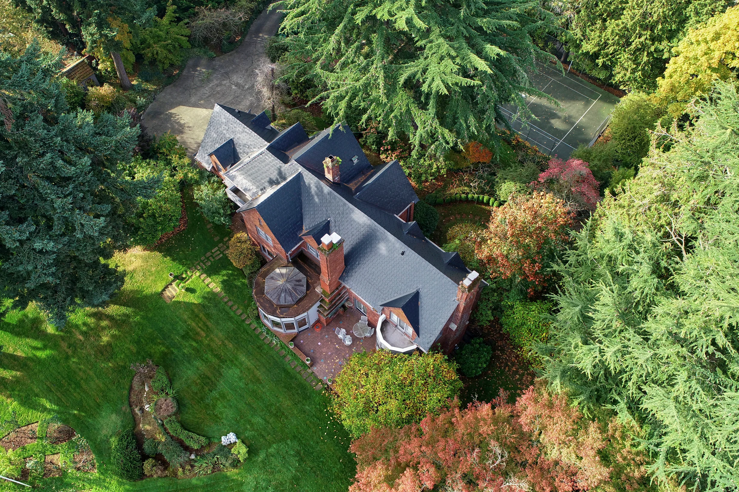 Black Interlock Slate aluminum roof on a red brick home with dormers in a lush green Seattle, Seattle, Washington