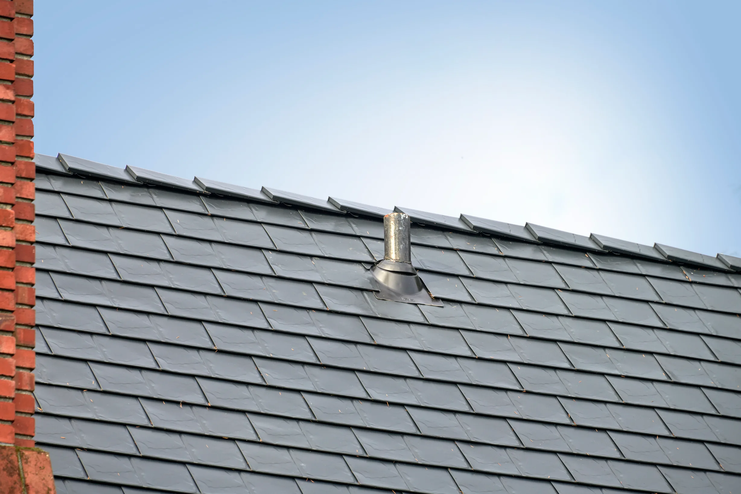 Black Interlock Slate aluminum roof on a black metal roof on a house with a brick chimney, Seattle, Washington