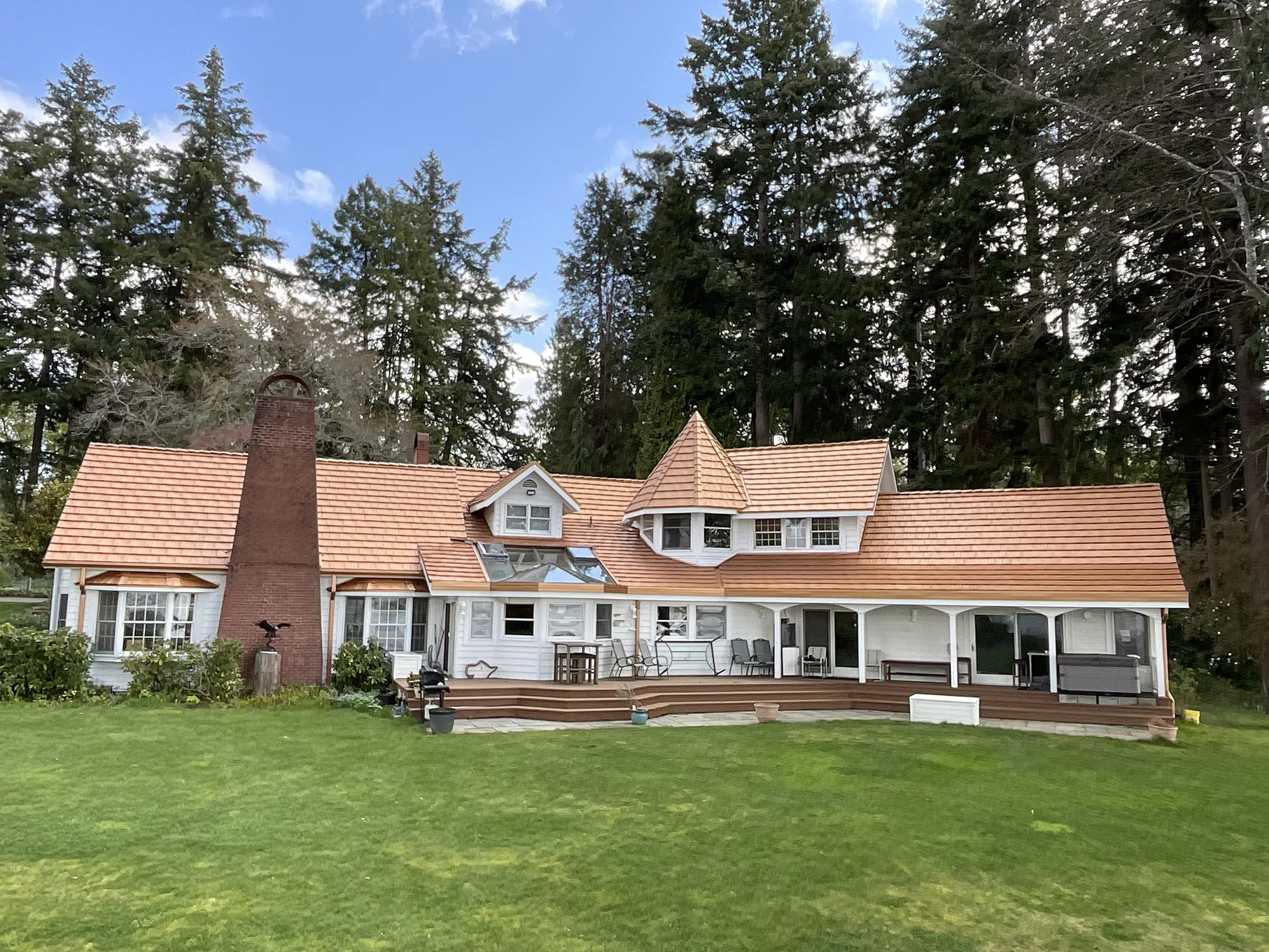Copper Penny Interlock Shake aluminum roof on a cottage-style home among tall evergreen trees, Bremerton, Washington