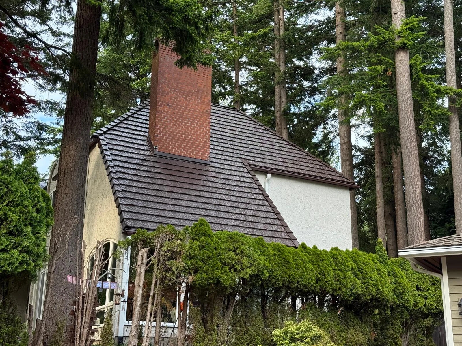 Colonial Brown Interlock Shake aluminum roof on a colonial home with a metal roof in a wooded rural setting, Bellingham, Washington