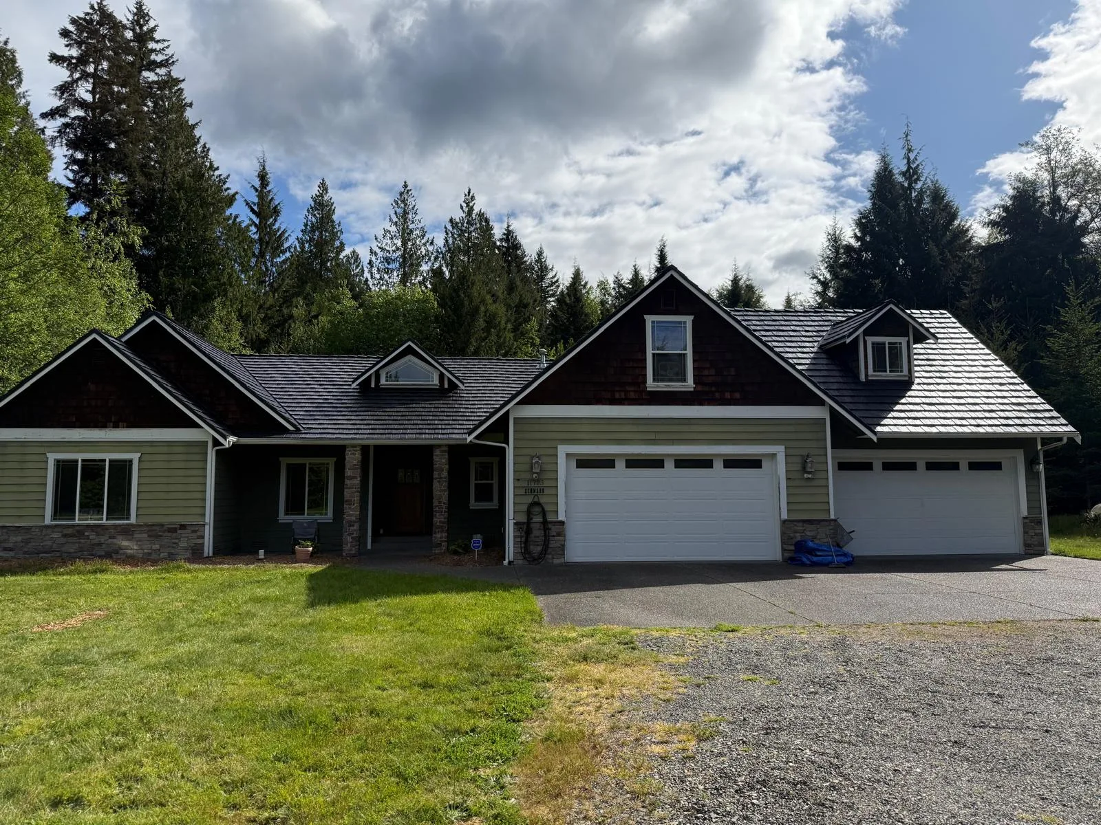 Black Interlock Shake aluminum roof on a two-storey home with black metal roof in a forested rural, Marysville, Washington