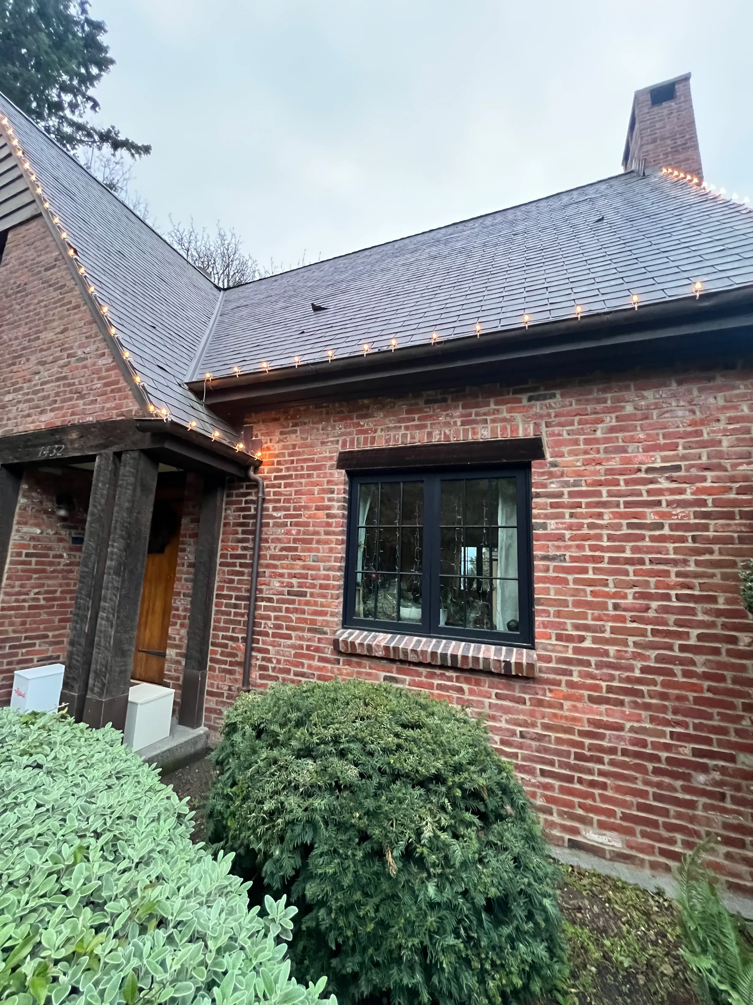 Deep Charcoal Interlock Slate aluminum roof on a red brick home with a metal roof in an urban setting, Seattle, Washington