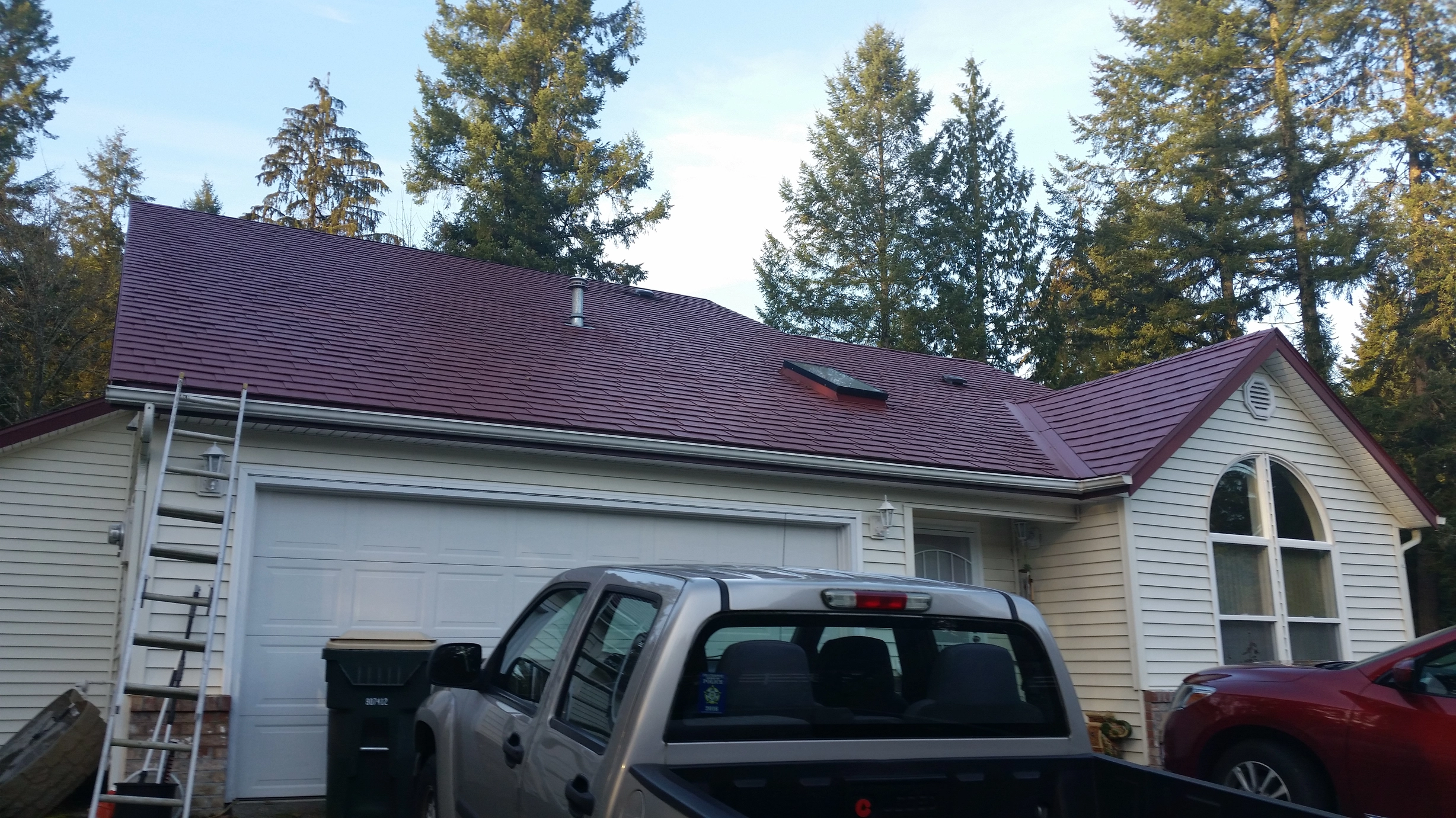 Tile Red Interlock Slate aluminum roof being installed on the home, replacing an asphalt shingle roof being torn off, Olympia, Washington
