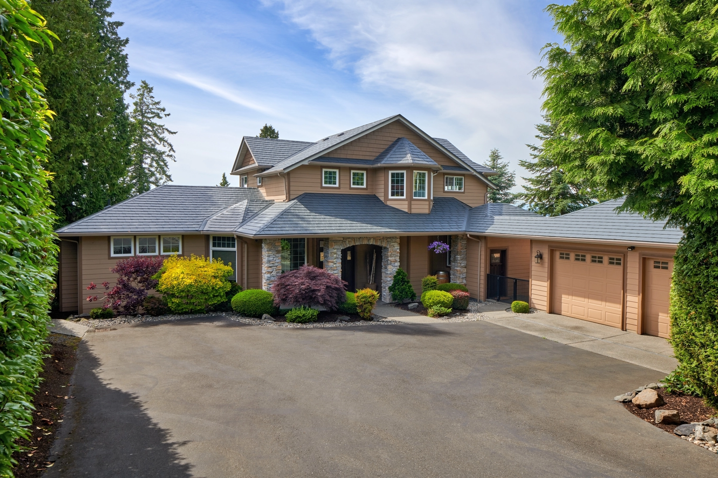 Deep Charcoal Interlock Slate aluminum roof on a beige single-storey home with a metal roof in a forested, Blaine, Washington