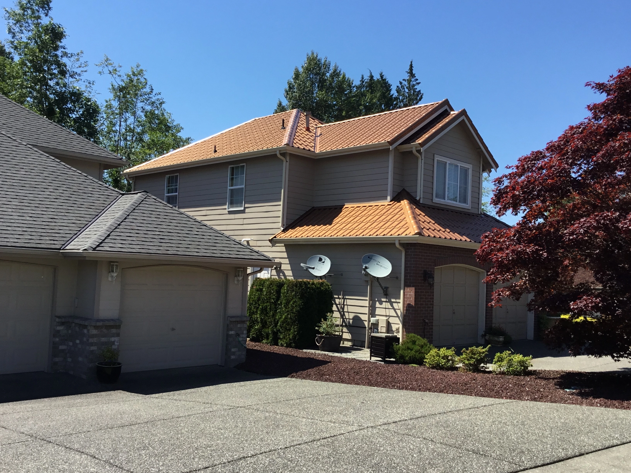 Aged Copper Interlock Tile aluminum roof on a two-storey home with a metal roof and dormers in a, Arlington, Washington