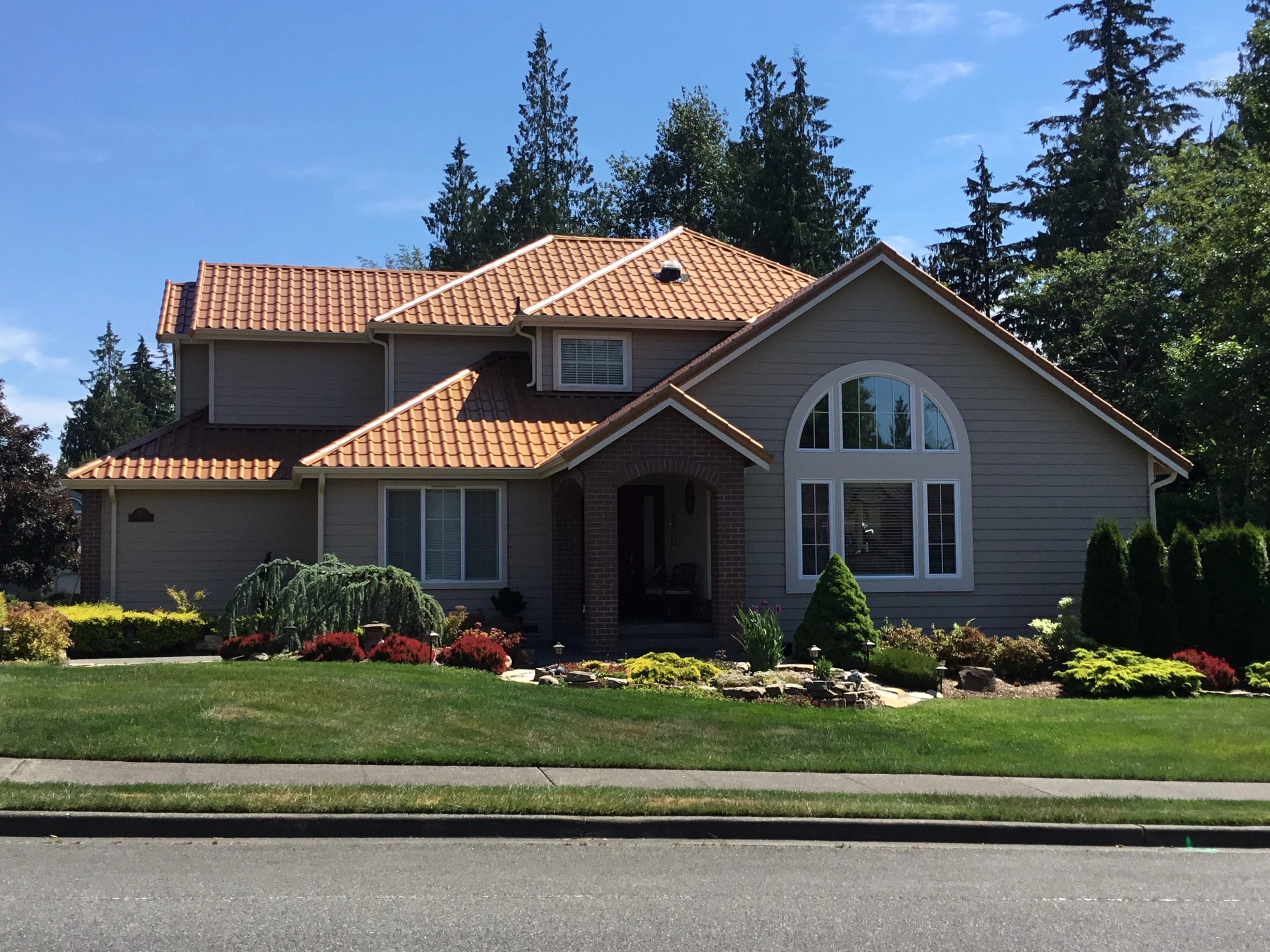 Aged Copper Interlock Tile aluminum roof on a two-storey home with dormers and an Interlock Tile roof, Arlington, Washington