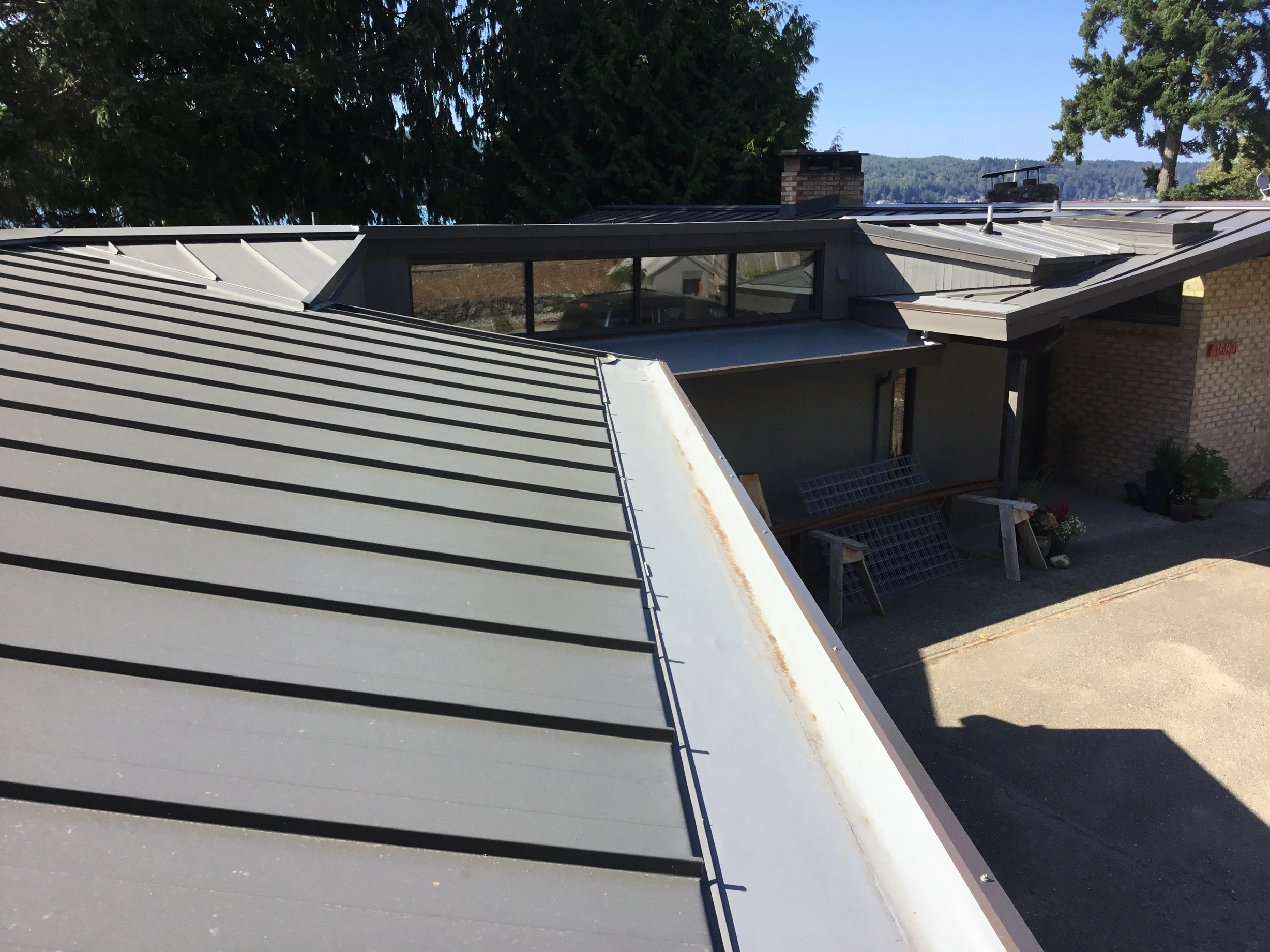 Musket Grey Interlock Standing Seam aluminum roof on a beige home with a metal roof near a body of water, Belfair, Washington