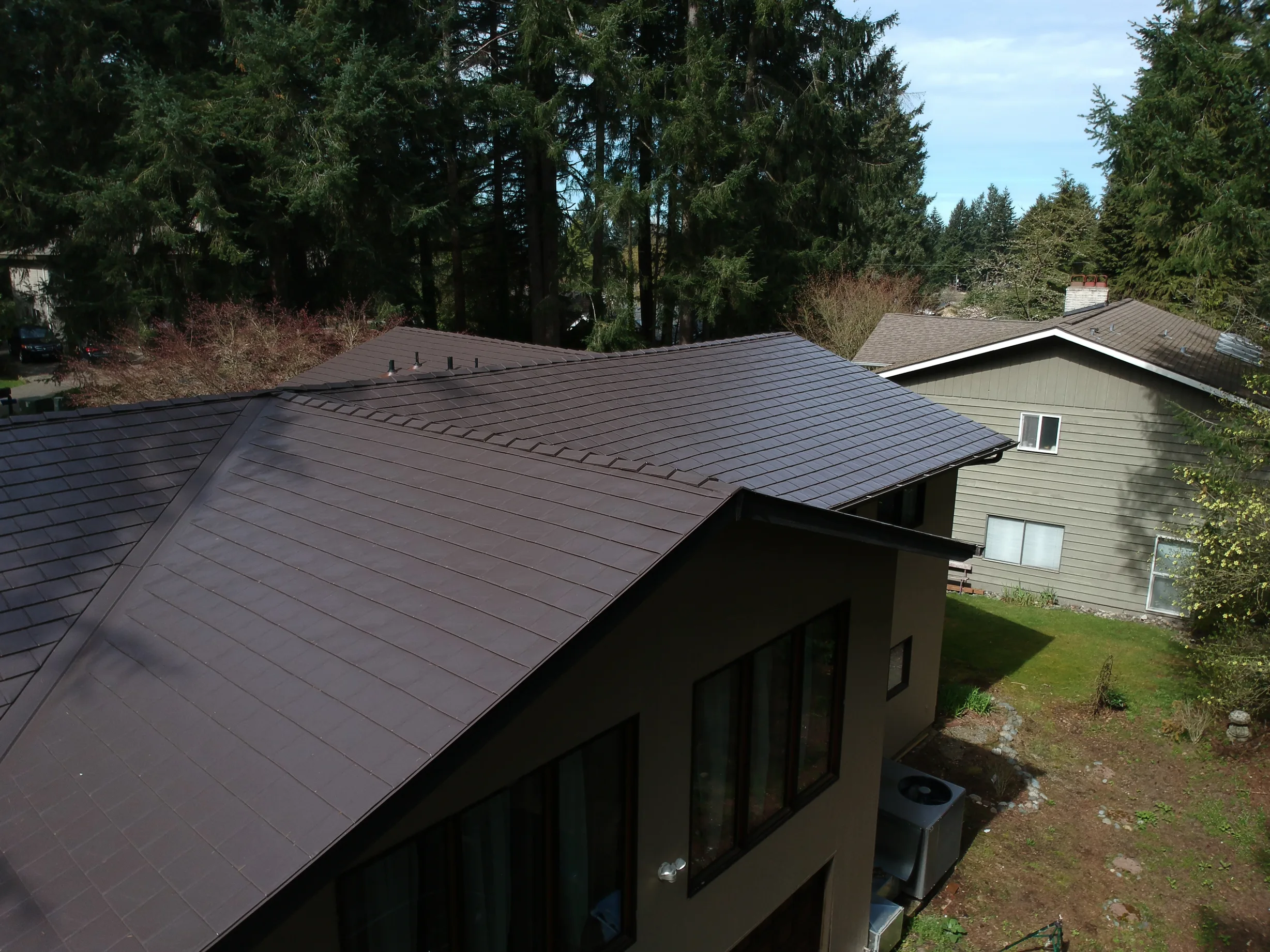 Tudor Brown Interlock Slate aluminum roof on a brown single-family home with a metal roof among, University Place, Washington