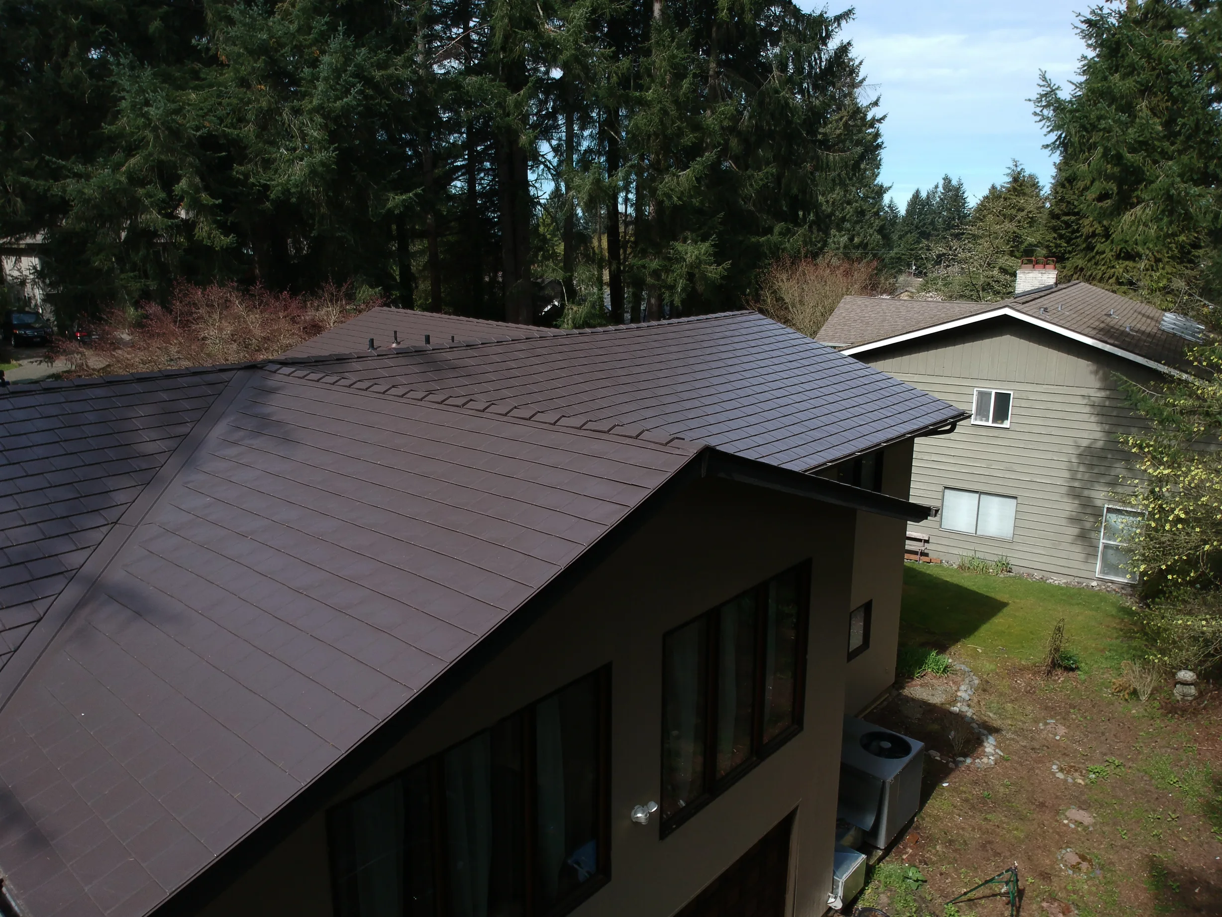 Tudor Brown Interlock Slate aluminum roof on a house with a brown metal roof in a forested area, University Place, Washington