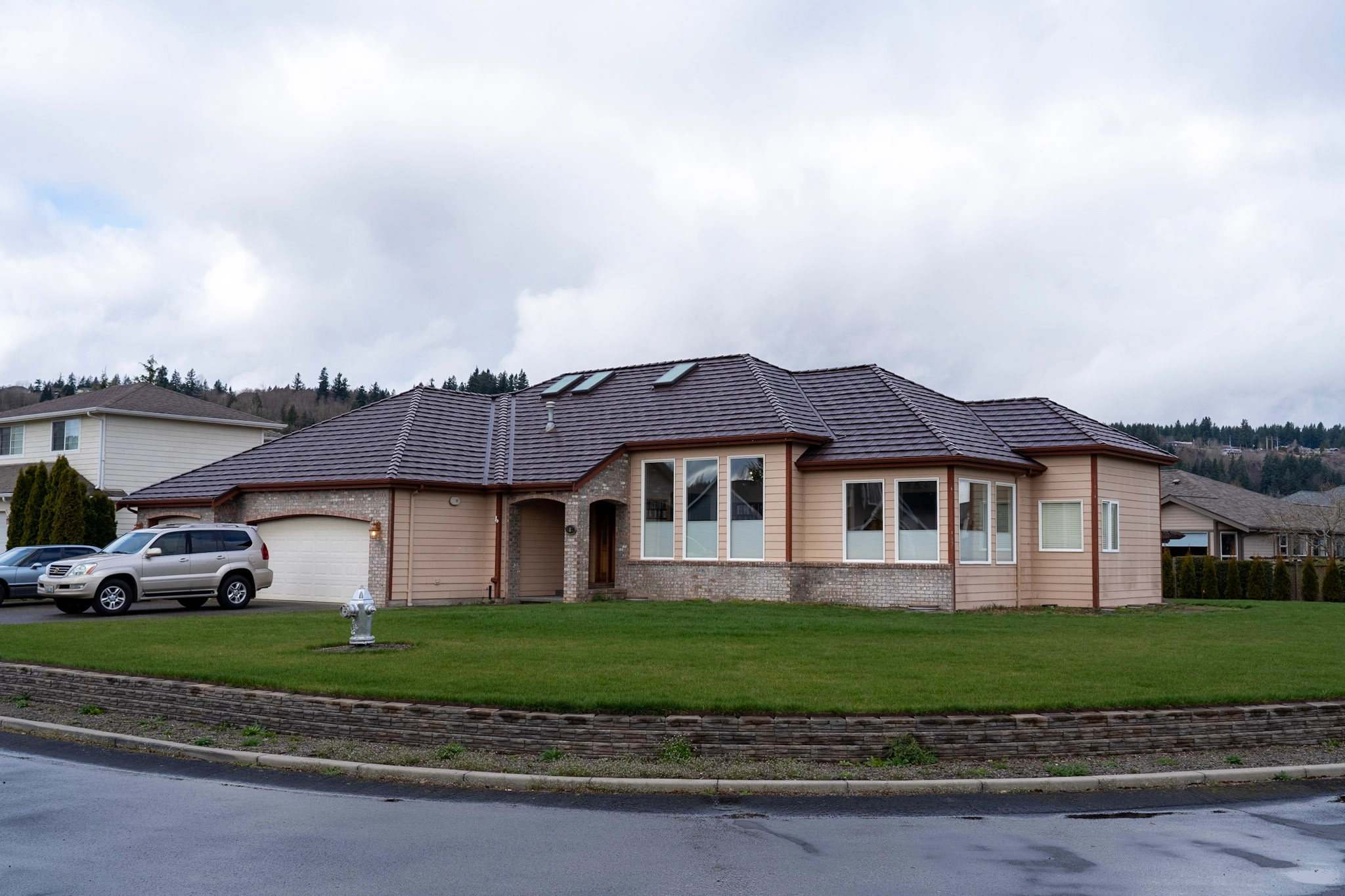 Colonial Brown Interlock Shake aluminum roof on a Colonial brown home with two stories on a suburban street, Orting, Washington