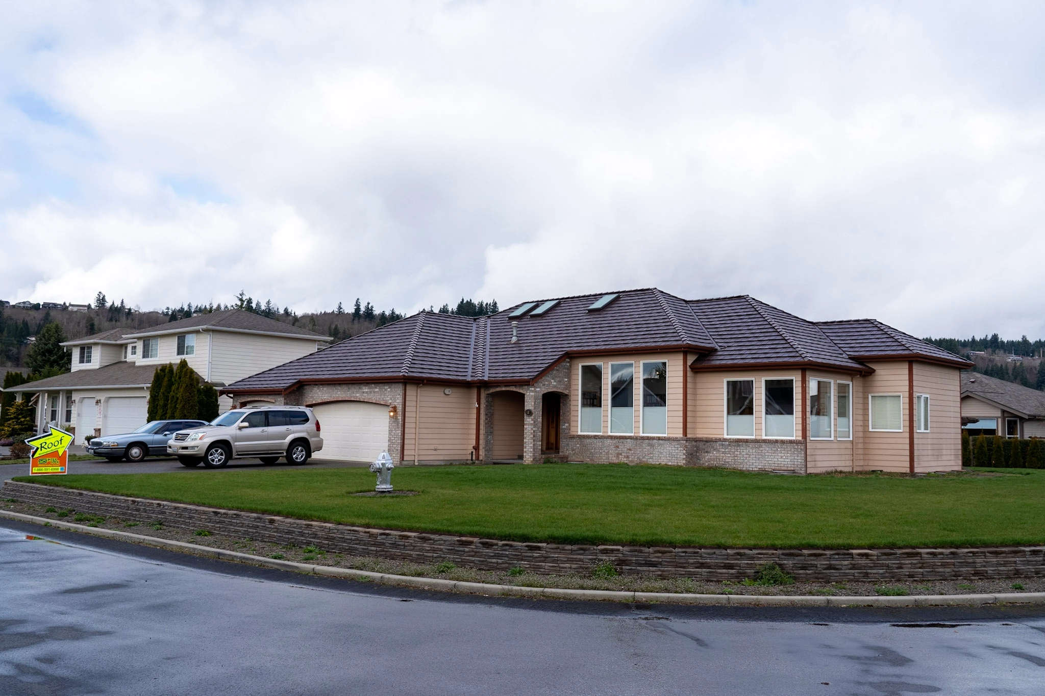Colonial Brown Interlock Shake aluminum roof on a tan home with a brown roof among green trees, Orting, Washington