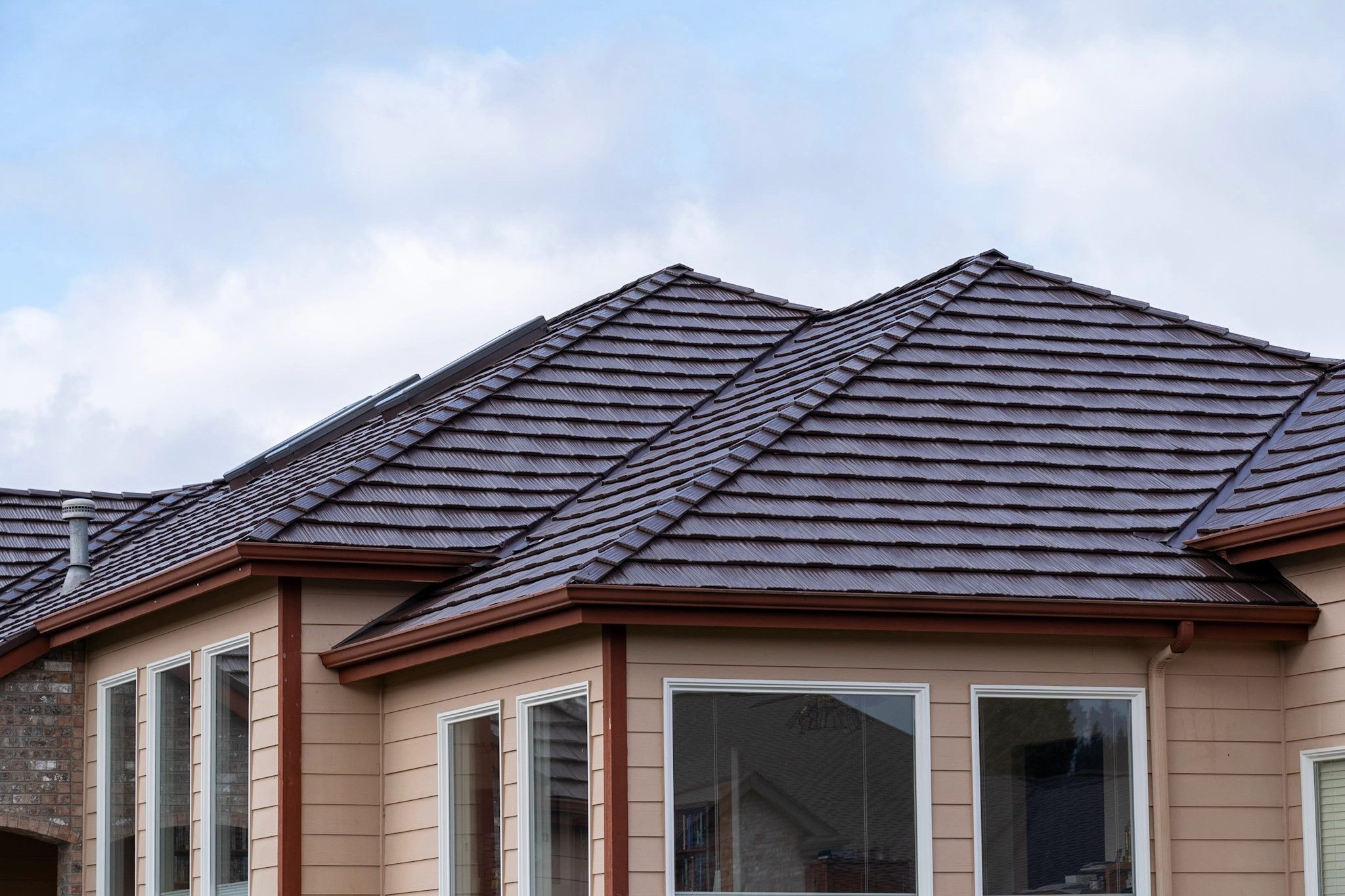 Colonial Brown Interlock Shake aluminum roof on a tan colonial home with a brown metal roof in a suburban, Orting, Washington