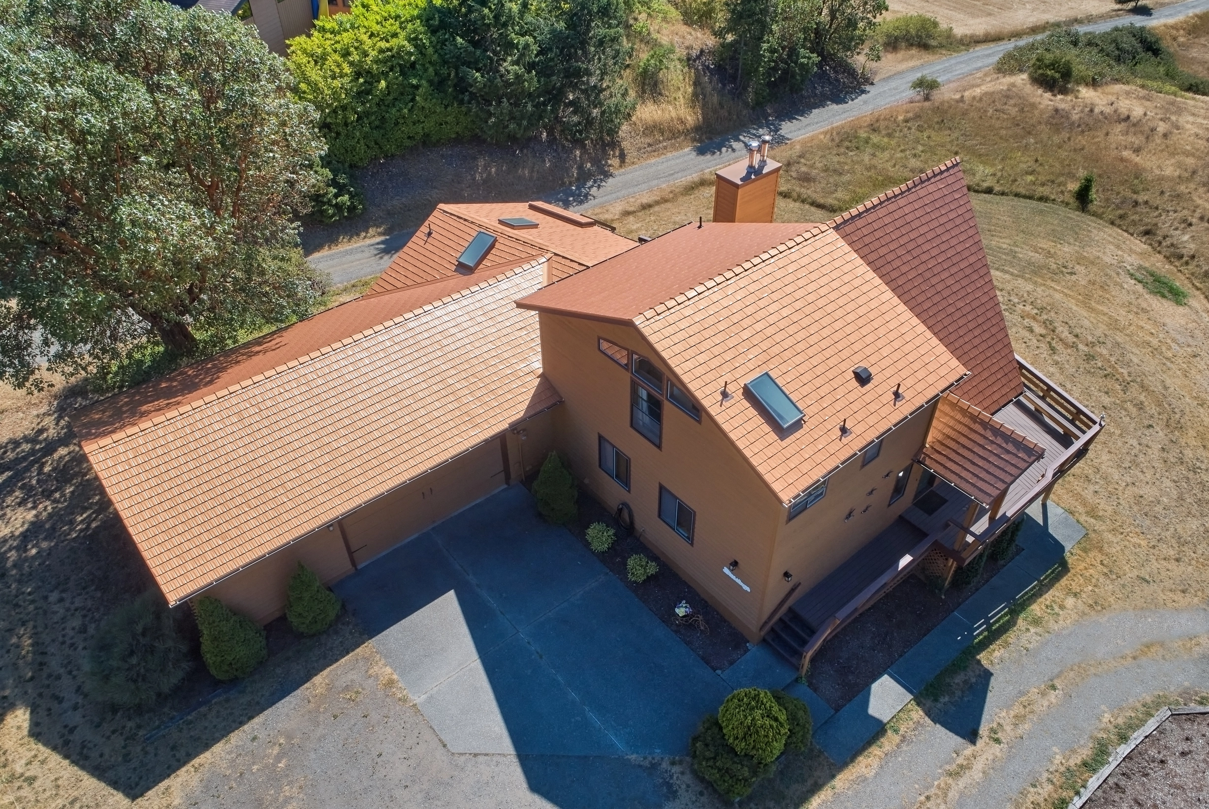Copper Penny Interlock Cedar Shingle aluminum roof on a two-storey home with dormers in a rural setting, Sequim, Washington