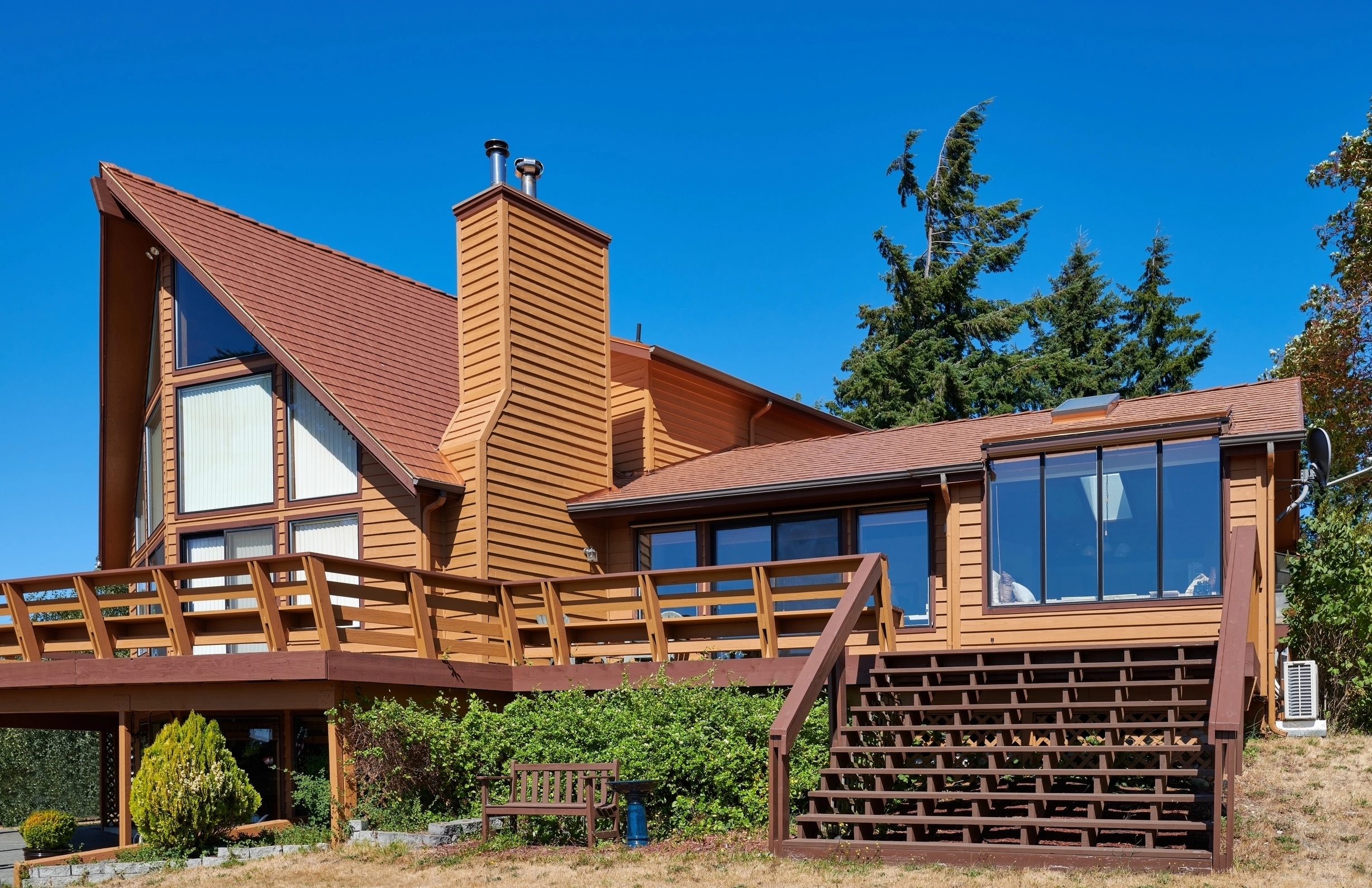 Copper Penny Interlock Cedar Shingle aluminum roof on a brown A-Frame home with a metal roof in a forested rural, Sequim, Washington