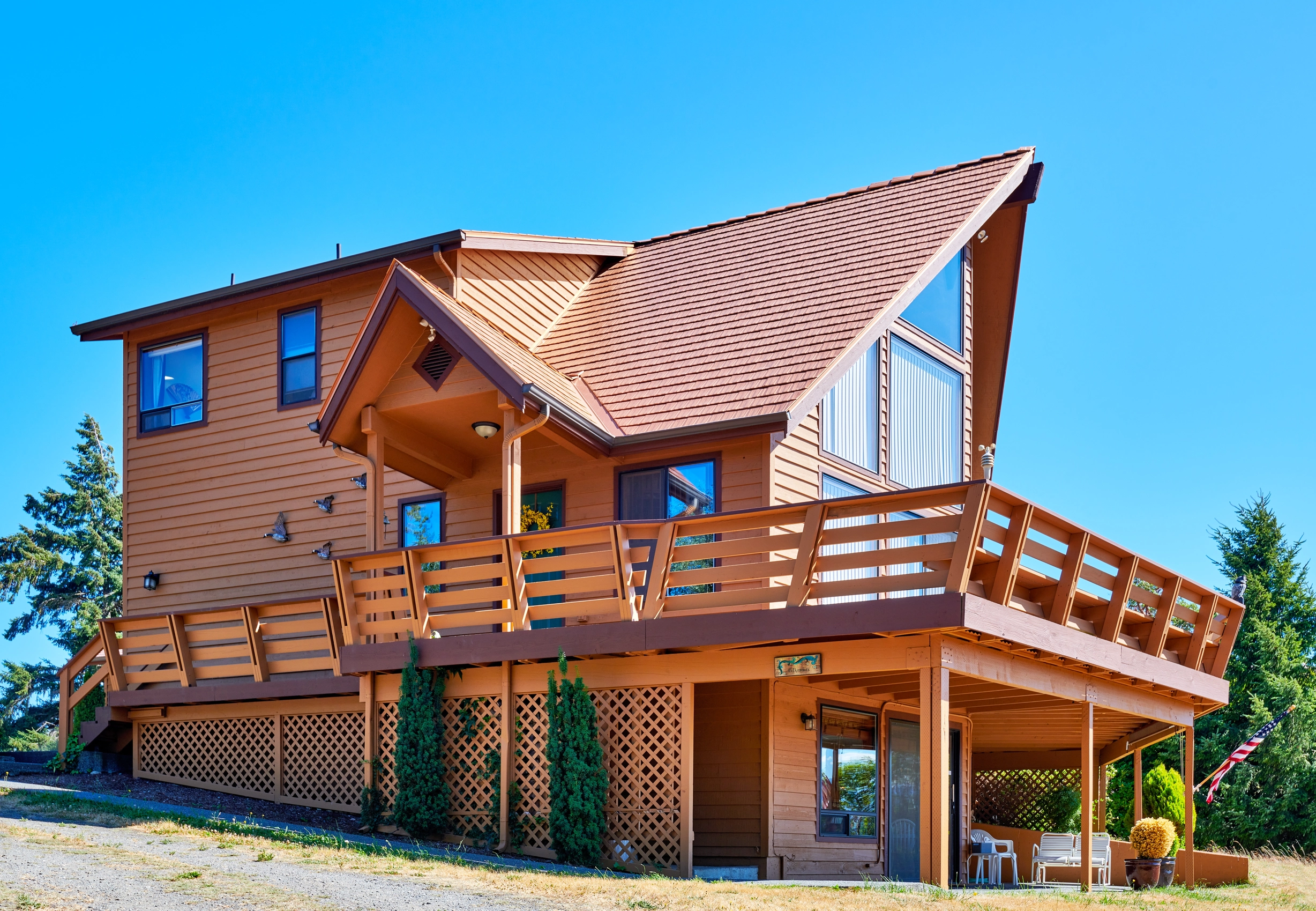 Copper Penny Interlock Cedar Shingle aluminum roof on a two-storey chalet with a copper penny metal roof in the, Sequim, Washington