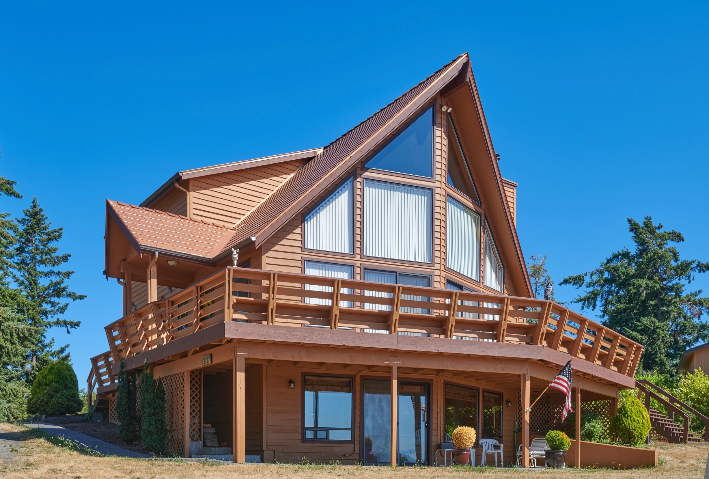 Copper Penny Interlock Cedar Shingle aluminum roof on a brown A-frame home with a metal roof near a forest, Sequim, Washington
