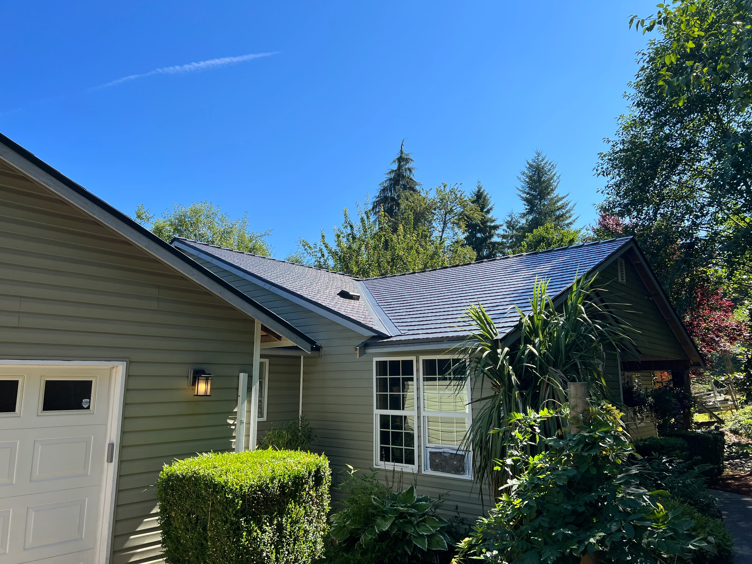 Deep Charcoal Interlock Cedar Shingle aluminum roof on a green single-storey ranch home with dormers in a forest, Longview, Washington