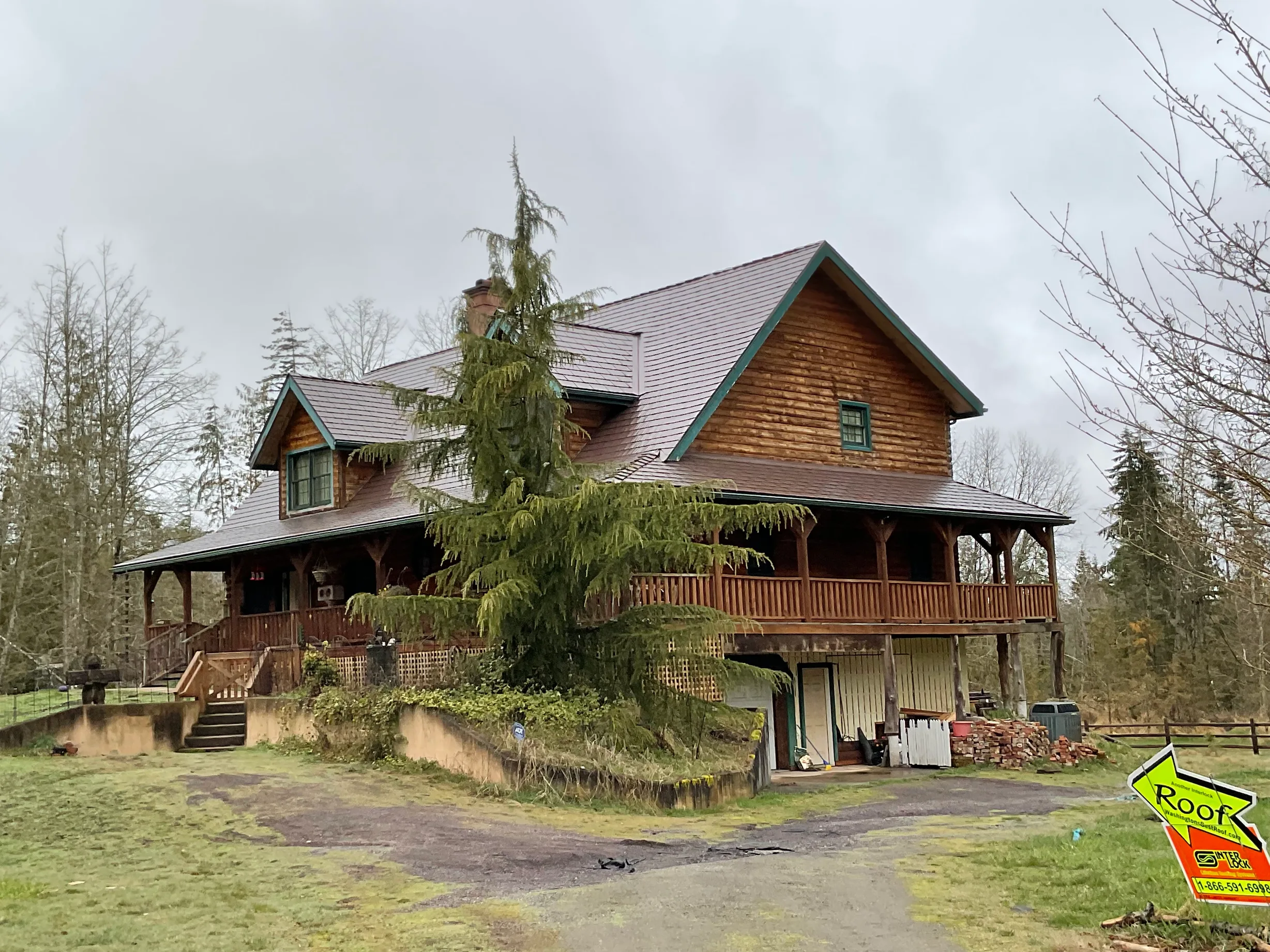 Colonial Brown Interlock Cedar Shingle aluminum roof on a colonial style home with a metal roof among tall trees, Port Angeles, Washington