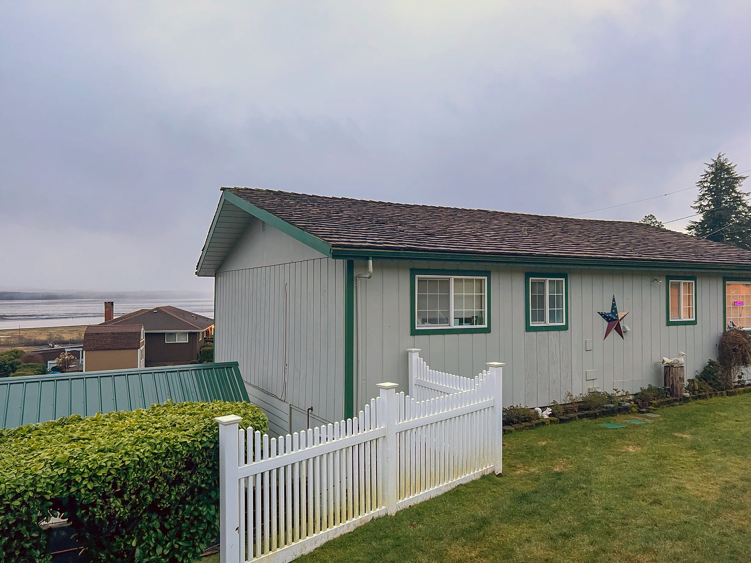 Before: a wind damaged wood shake roof on the home, Hoquiam, Washington, ahead of a Copper Penny Interlock Cedar Shingle aluminum roof
