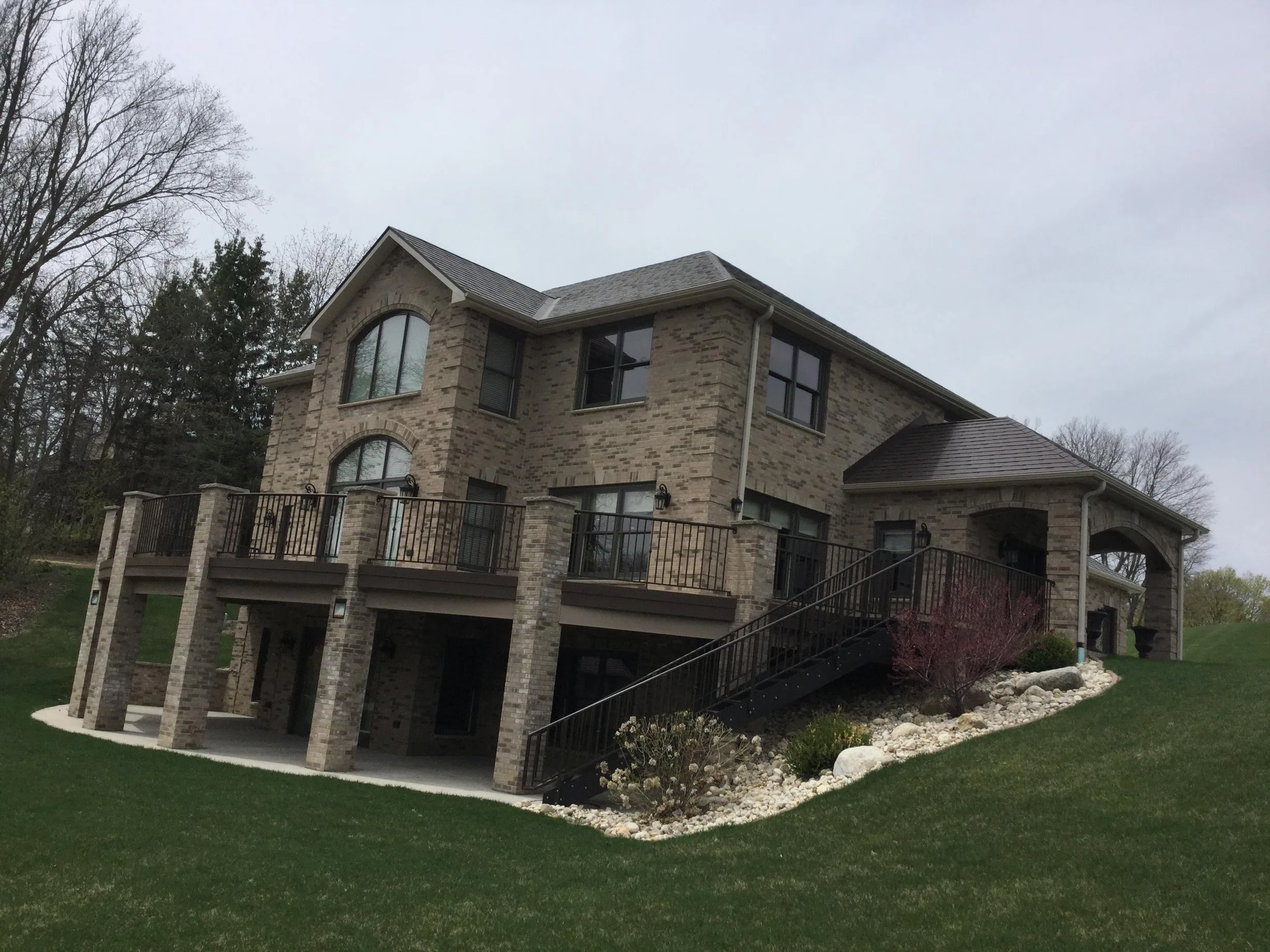 Colonial Brown Interlock Slate aluminum roof on a brown two-storey home with dormers in a wooded rural, Horicon, Wisconsin