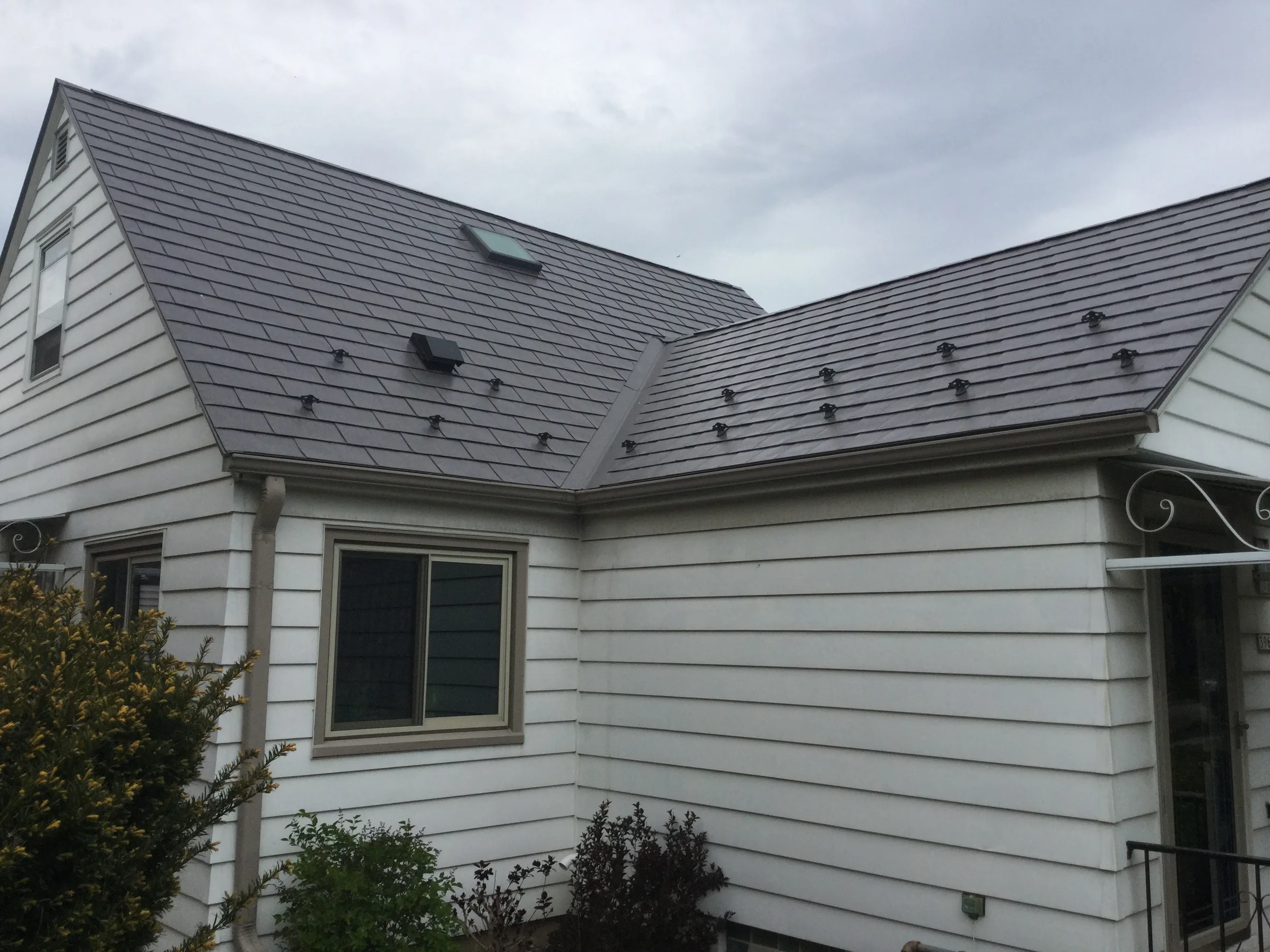 Weathered Interlock Slate aluminum roof on a white single-family home with a metal roof in an urban, Milwaukee, Wisconsin