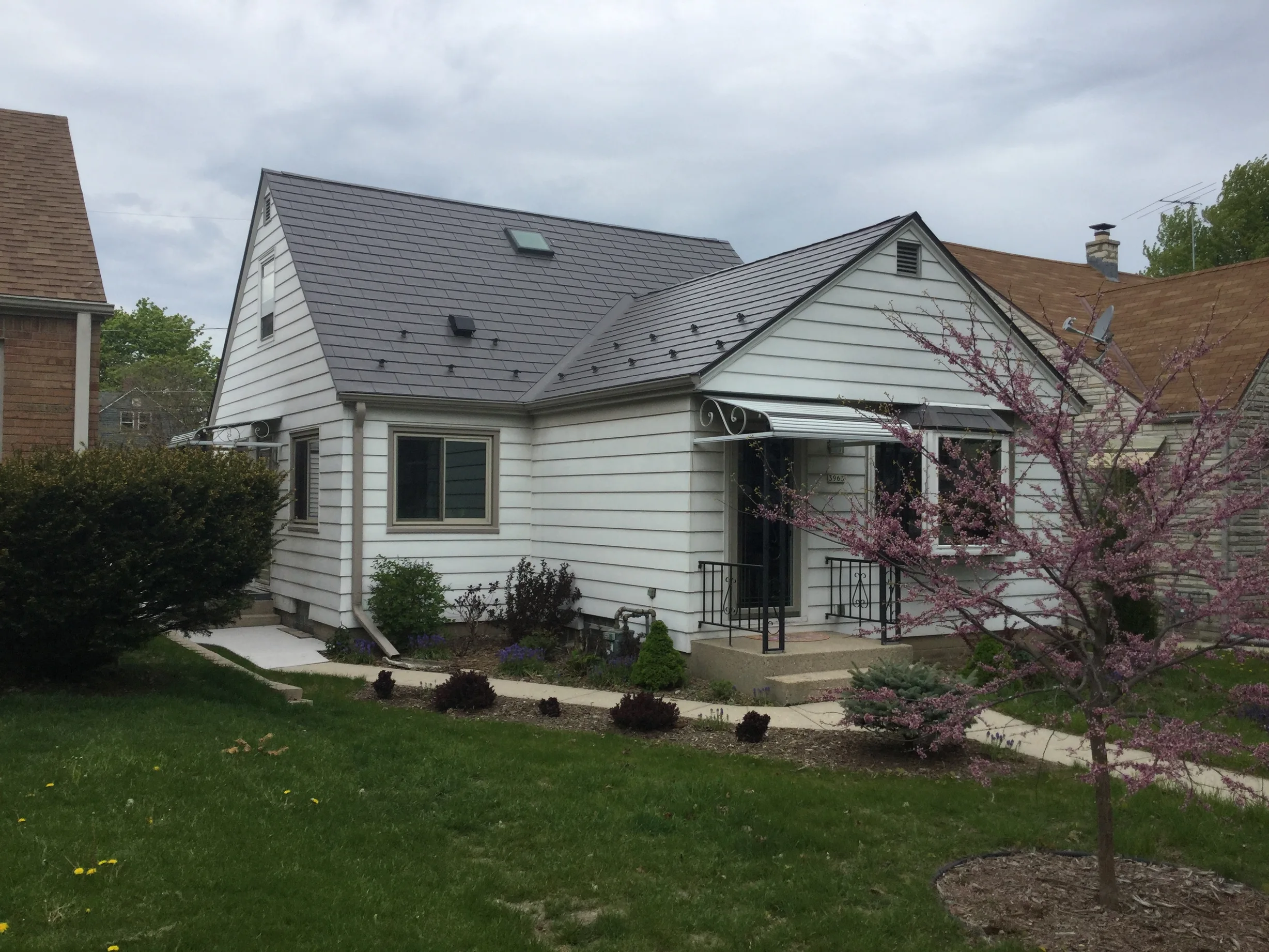 Weathered Interlock Slate aluminum roof on a white ranch home with a brown roof among trees, Milwaukee, Wisconsin