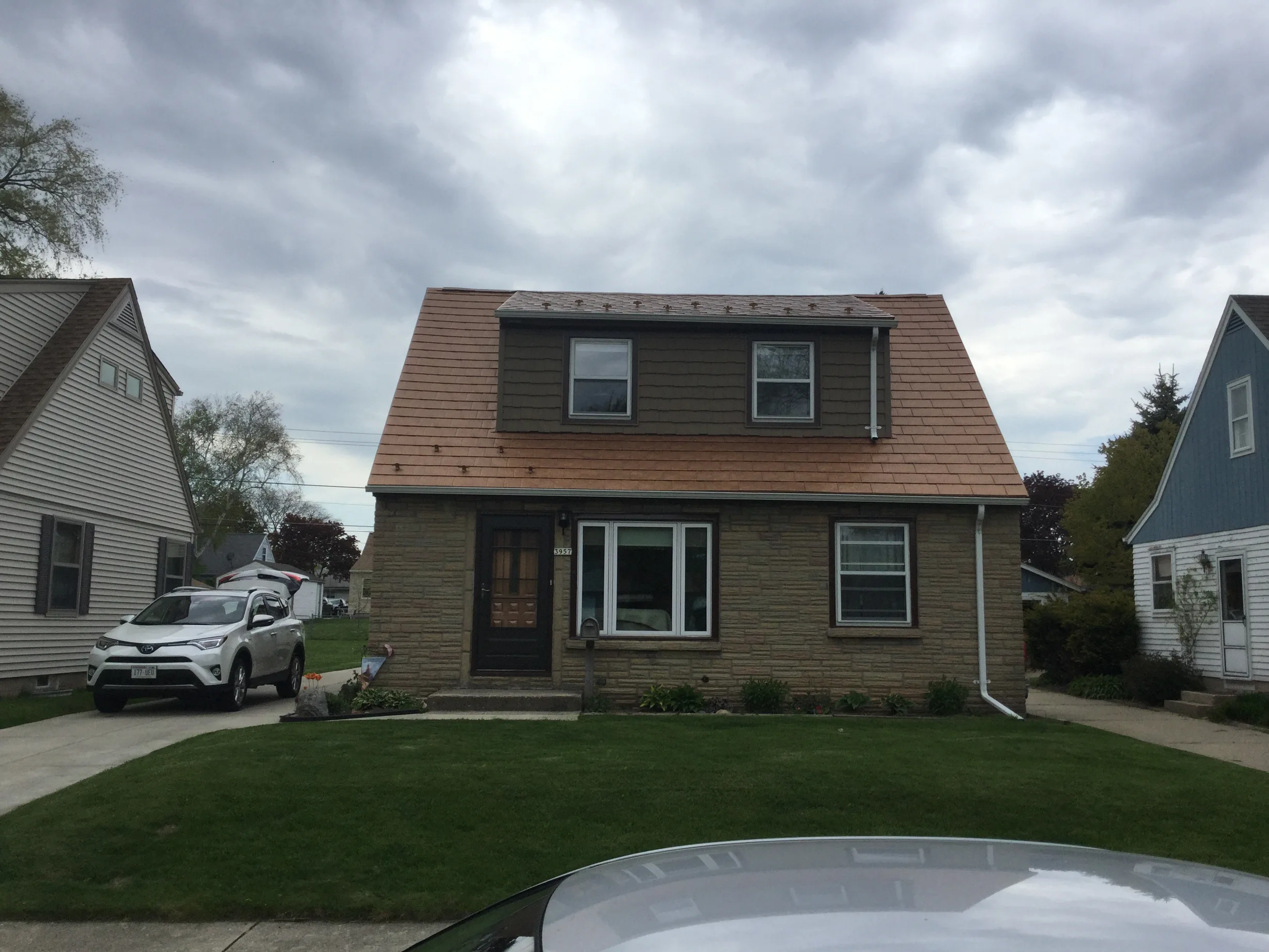 Aged Copper Interlock Slate aluminum roof on a brown Colonial home with dormers in an urban-suburban, Milwaukee, Wisconsin