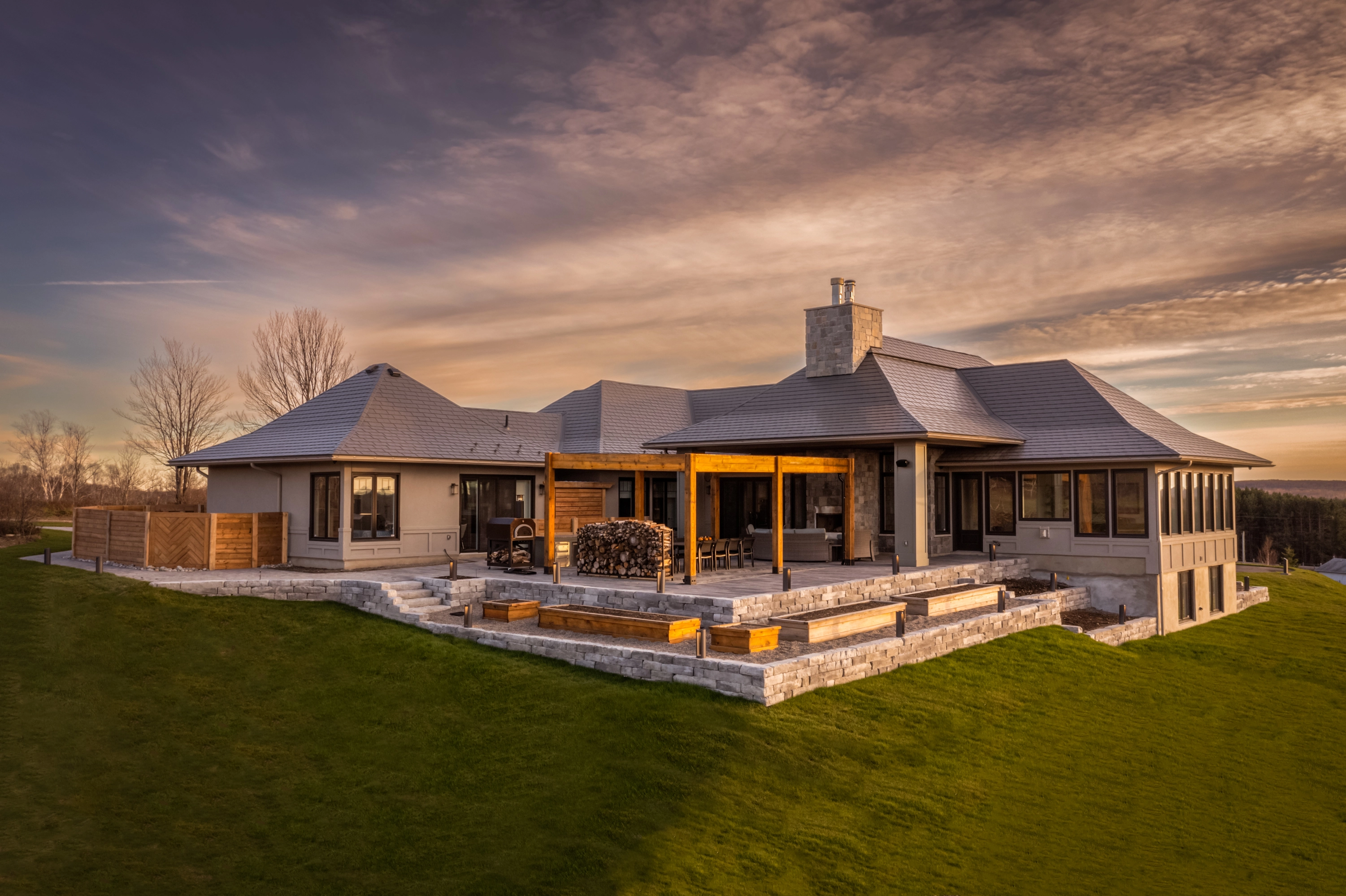 Contemporary home with Interlock aluminum shingles on a multi-pitched roof at sunset
